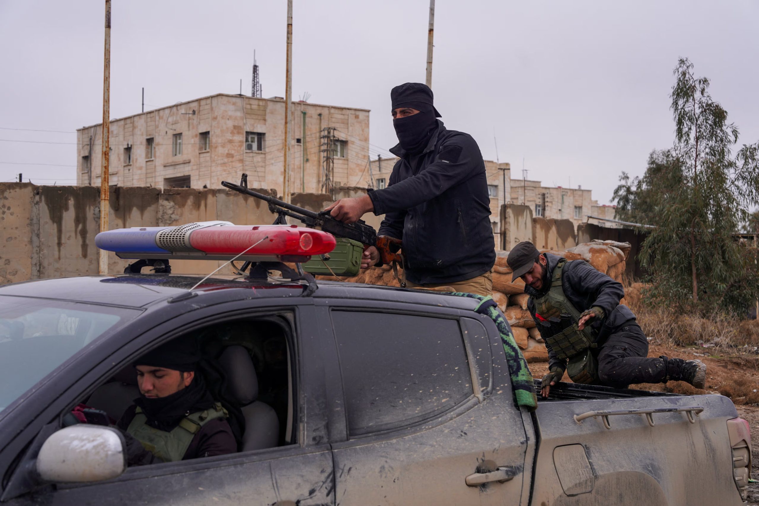 Un miembro de las fuerzas de seguridad sirias en la parte trasera de un vehículo, en el exterior de la prisión de al-Aqtan, donde se encuentran algunos detenidos del Estado Islámico, en Raqqa, Siria, 23 de enero de 2026
REUTERS/Karam al-Masri