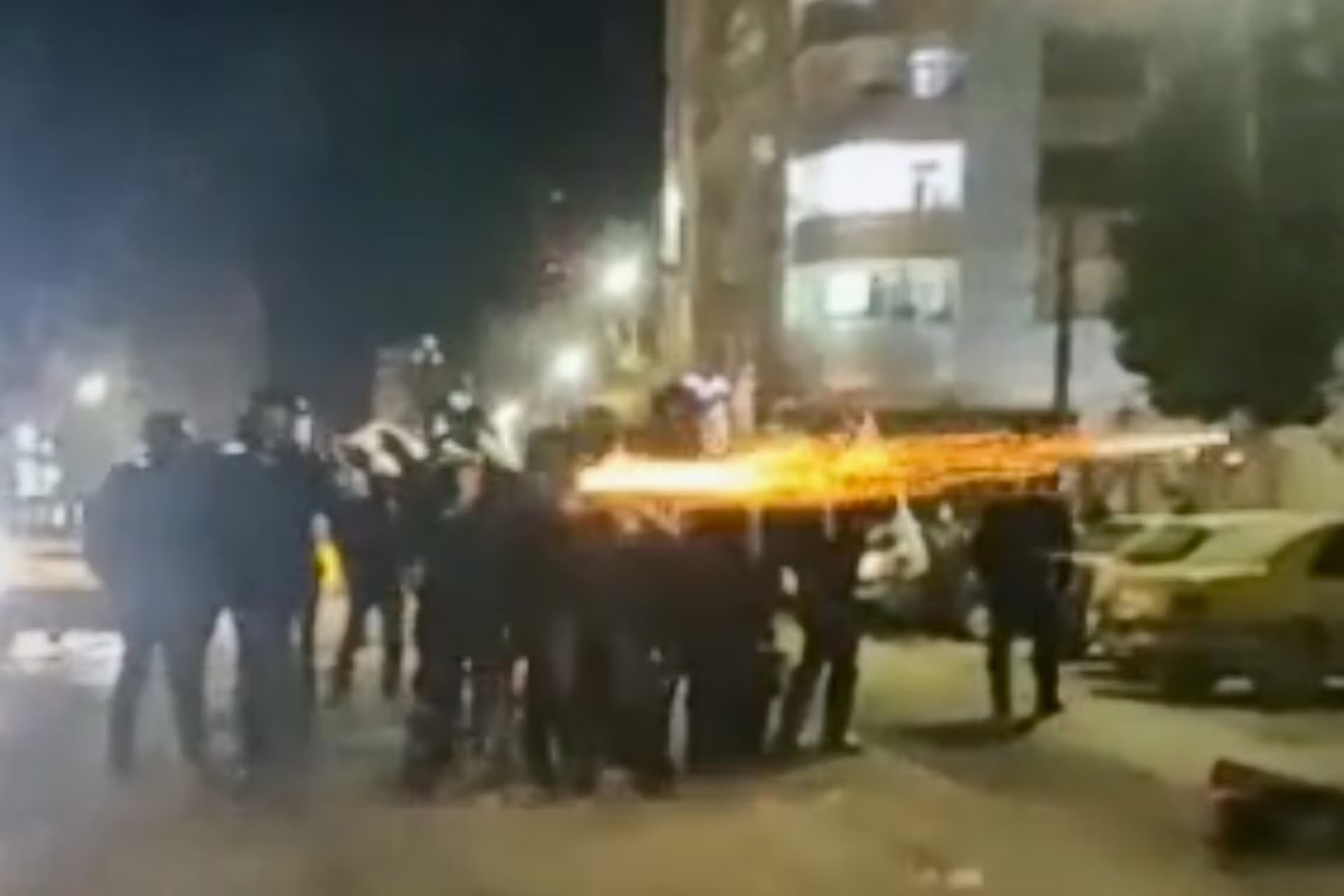 Individuos se congregan en una calle de Irán, donde algunos yacen en el suelo junto a cubiertas que contienen cuerpos, mientras otros observan la sombría escena. (AP)