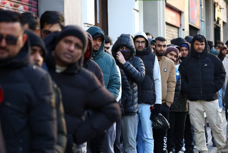 Cola frente al consulado de Pakistán en Barcelona para solicitar certificados de antecedentes penales, un documento necesario para el programa de regularización migratoria anunciado recientemente por el Gobierno español, en Barcelona, España, el 30 de enero de 2026. (REUTERS/Albert Gea)
