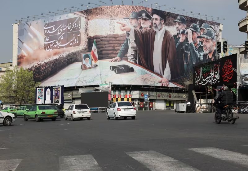 Varios autos pasan junto a una pancarta con la imagen del nuevo líder supremo de Irán, Mojtaba Khamenei, en Teherán, Irán. 14 de marzo de 2026 (Majid Asgaripour/WANA vía Reuters)