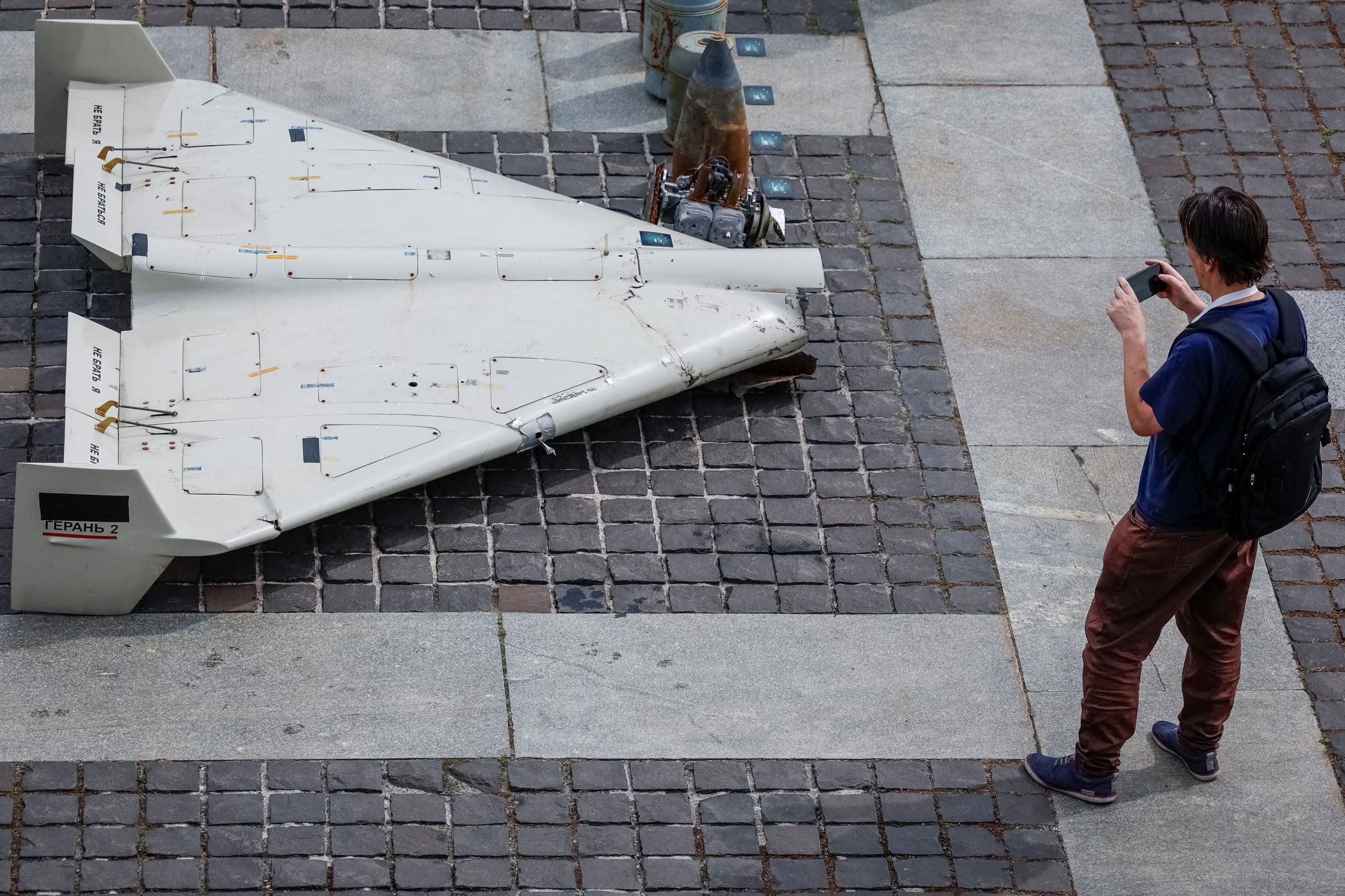 Un hombre toma una fotografía de partes de un vehículo aéreo no tripulado (VANT) Shahed-131/136 de fabricación iraní (REUTERS/Alina Smutko/Archivo)