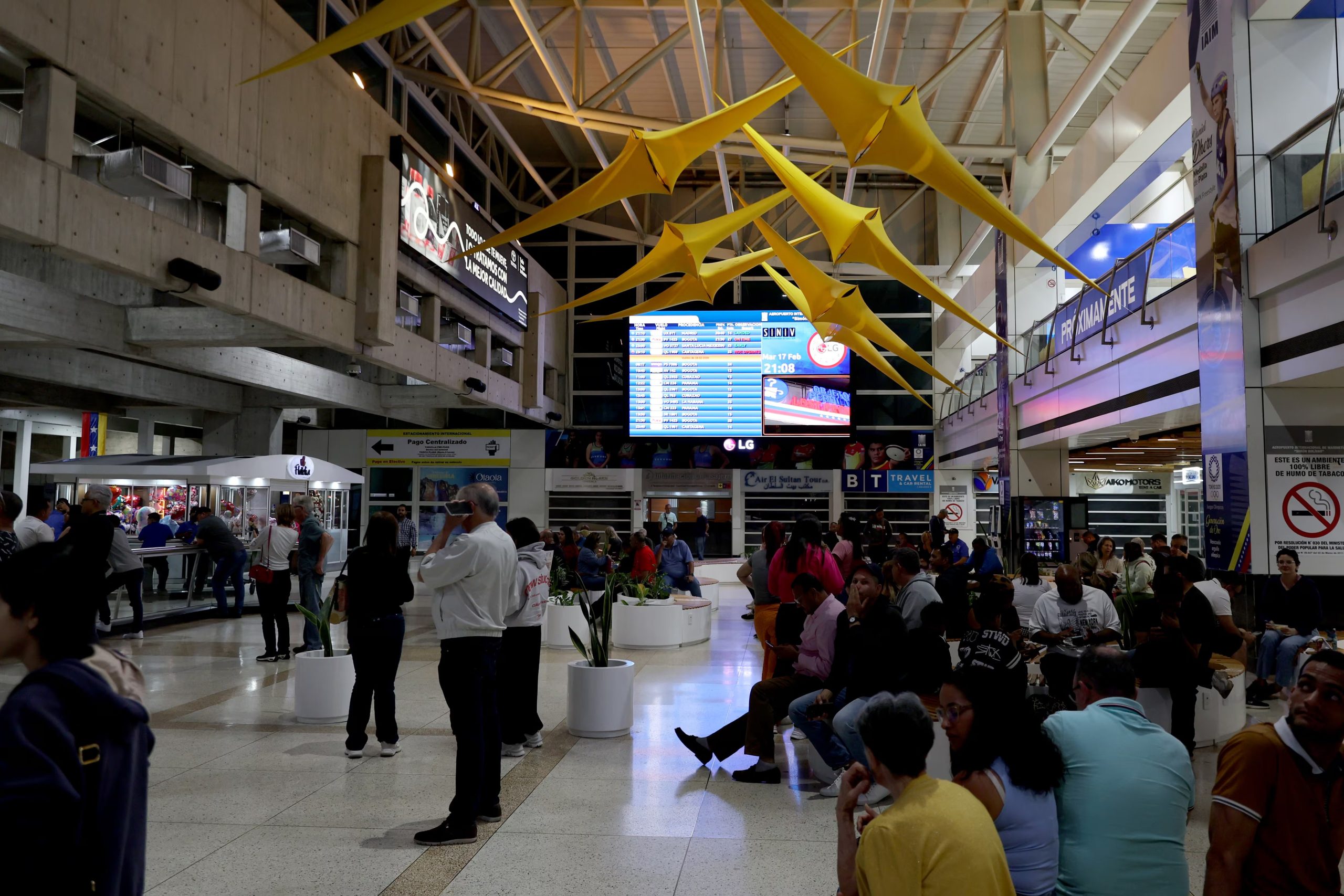 Varias personas esperan abordar sus vuelos en el aeropuerto internacional de Maiquetía, en Caracas (EFE/ Miguel Gutierrez)
