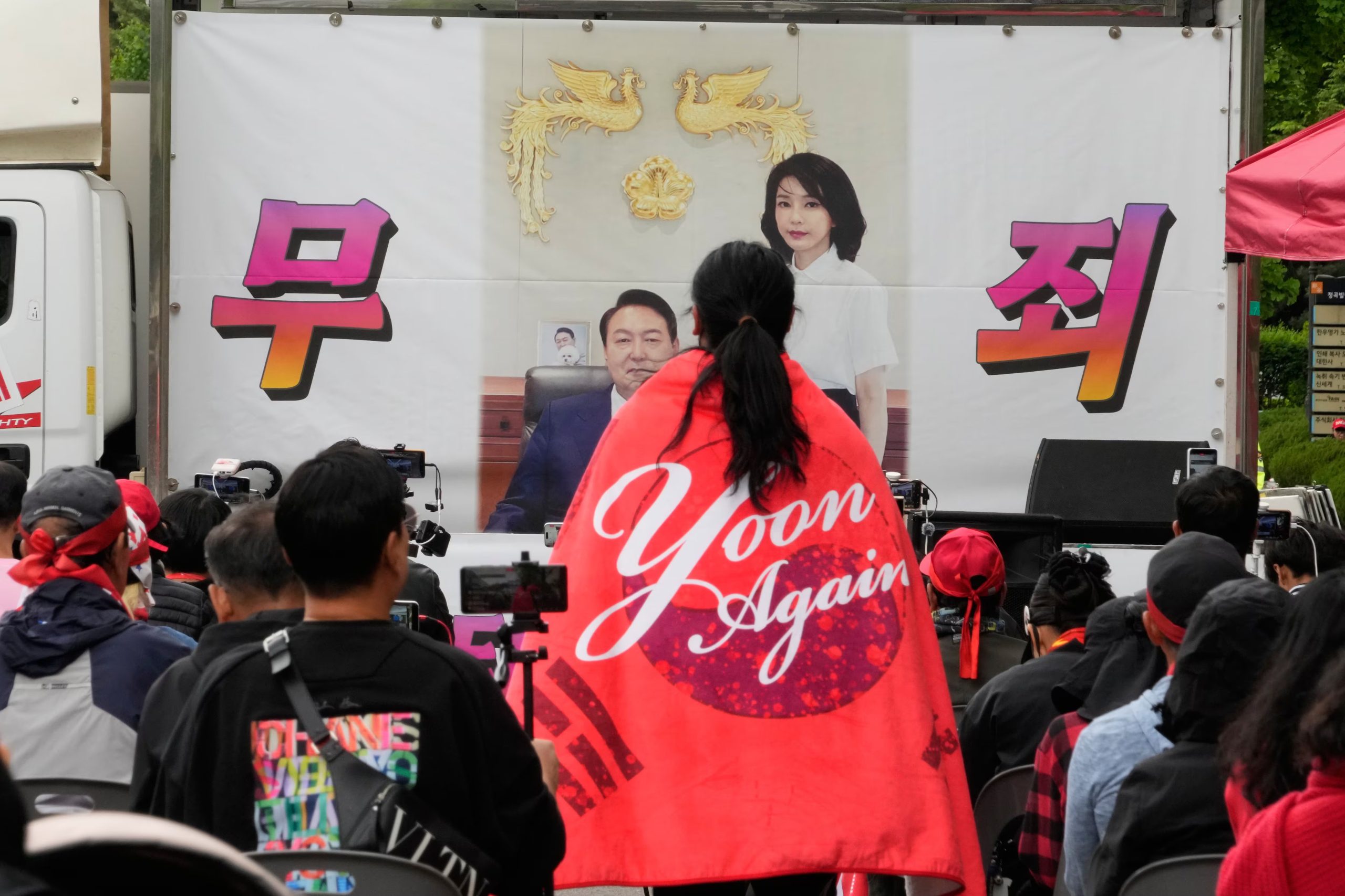 Una imagen del expresidente surcoreano Yoon Suk Yeol y su esposa Kim Keon Hee se ve durante una marcha de partidarios ante el Alto Tribunal de Seúl, en Seúl, Corea del Sur, el martes 28 de abril de 2026. Las letras dicen 