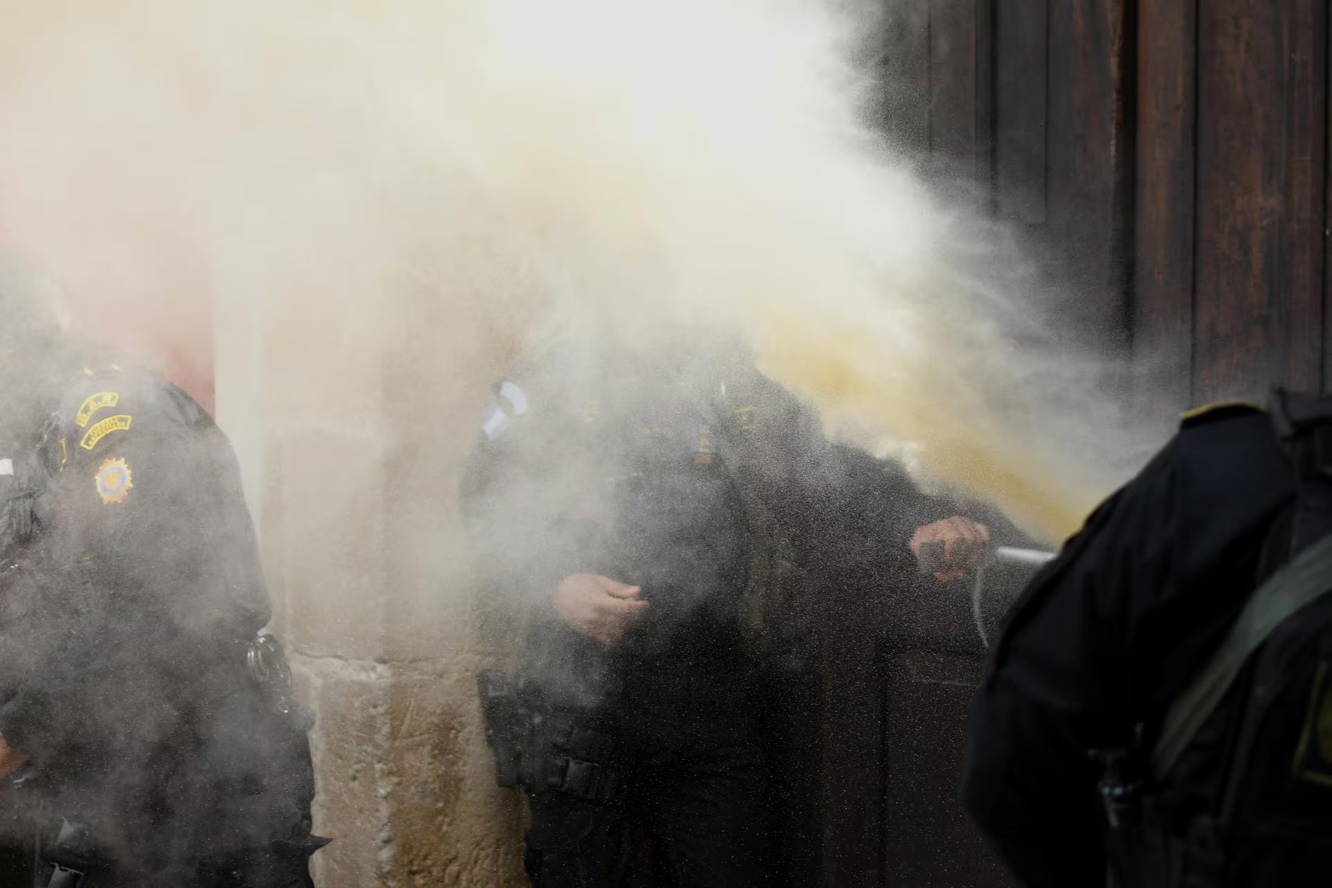 Agentes de la Policía Nacional Civil sufren el lanzamiento de gases lacrimógenos este miércoles, en un hotel de Antigua Guatemala (Guatemala). Los gases lacrimógenos fueron lanzados por supuesto personal vinculado a Walter Mazariegos que estaba a cargo de la seguridad de la elección, según las denuncias de los parlamentarios agredidos. (EFE/ Alex Cruz)