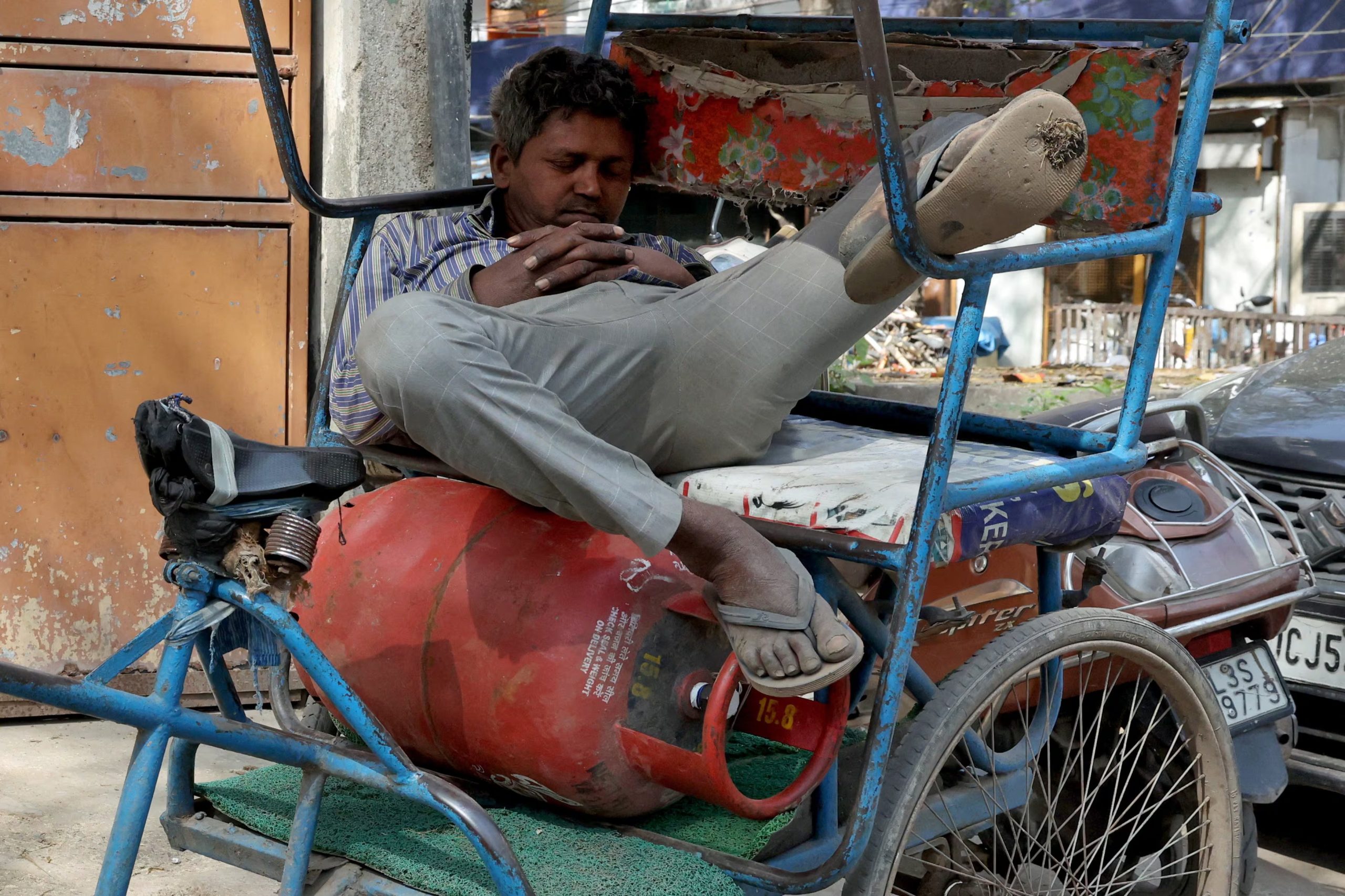 Un conductor descansa en su rickshaw mientras aguarda la reposición de gas. (REUTERS)