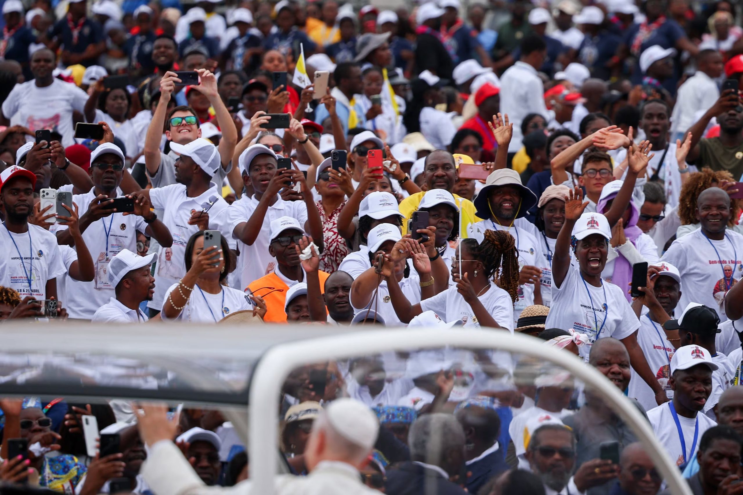 El papa León XIV saluda a los fieles a su llegada a Kilamba, donde muchos durmieron en el suelo la noche anterior para asistir a la misa campal. (Reuters/Guglielmo Mangiapane)