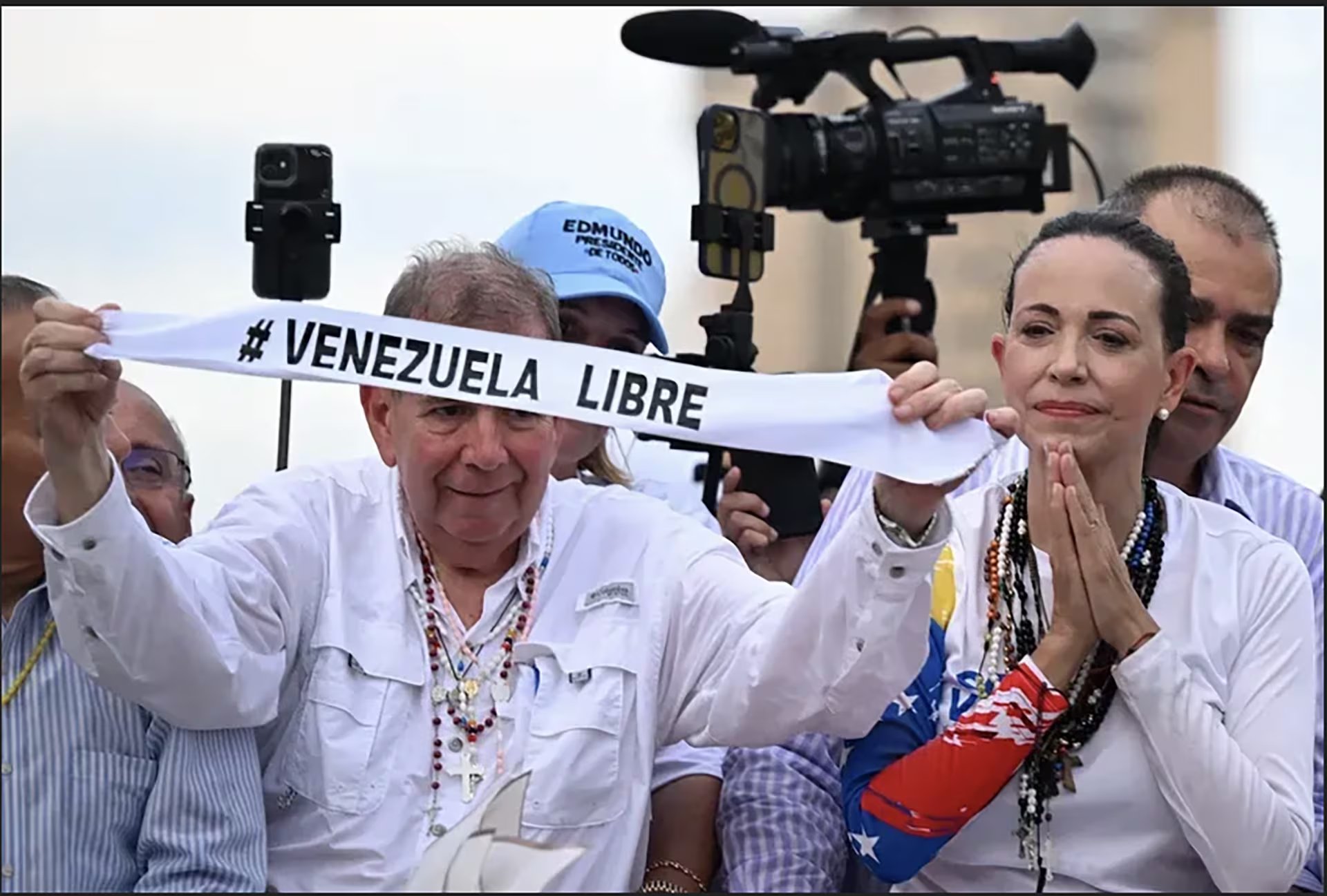 Edmundo González Urrutia y María Corina Machado sostienen una pancarta con el lema '#Venezuela Libre' durante un evento