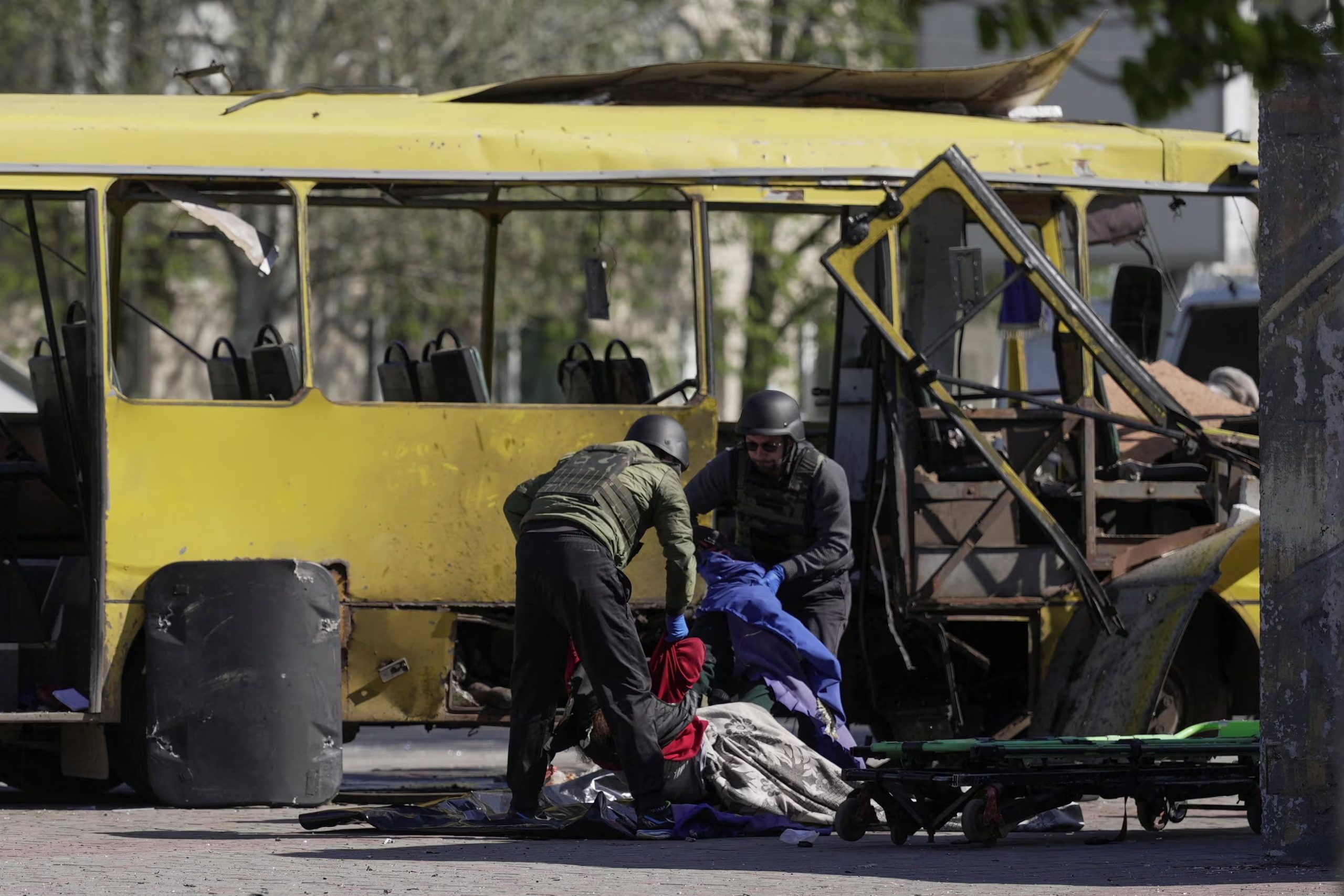 MATERIAL SENSIBLE. ESTA IMAGEN PUEDE RESULTAR OFENSIVA O PERTURBADORA. Hombres con equipo de protección recogen el cuerpo de un residente que murió dentro de un autobús municipal durante un ataque con drones rusos en la ciudad de Nikopol, en medio del ataque de Rusia contra Ucrania, en la región de Dnipropetrovsk, Ucrania, el 7 de abril de 2026. REUTERS/Stringer