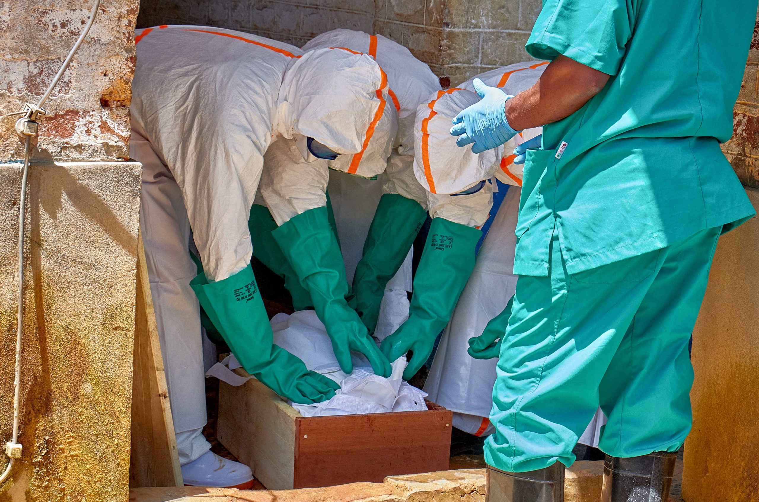 Trabajadores de la Cruz Roja, equipados con equipos de protección personal (EPP), colocan el cadáver de un niño fallecido por ébola en un ataúd, mientras las agencias de ayuda intensifican sus esfuerzos para contener un nuevo brote de ébola de la cepa Bundibugyo en Mongbwalu, territorio de Djugu, provincia de Ituri, República Democrática del Congo, el 24 de mayo de 2026. Los padres del niño permanecen en el centro de aislamiento del Hospital General de Referencia de Mongbwalu. REUTERS/Gradel Muyisa Mumbere