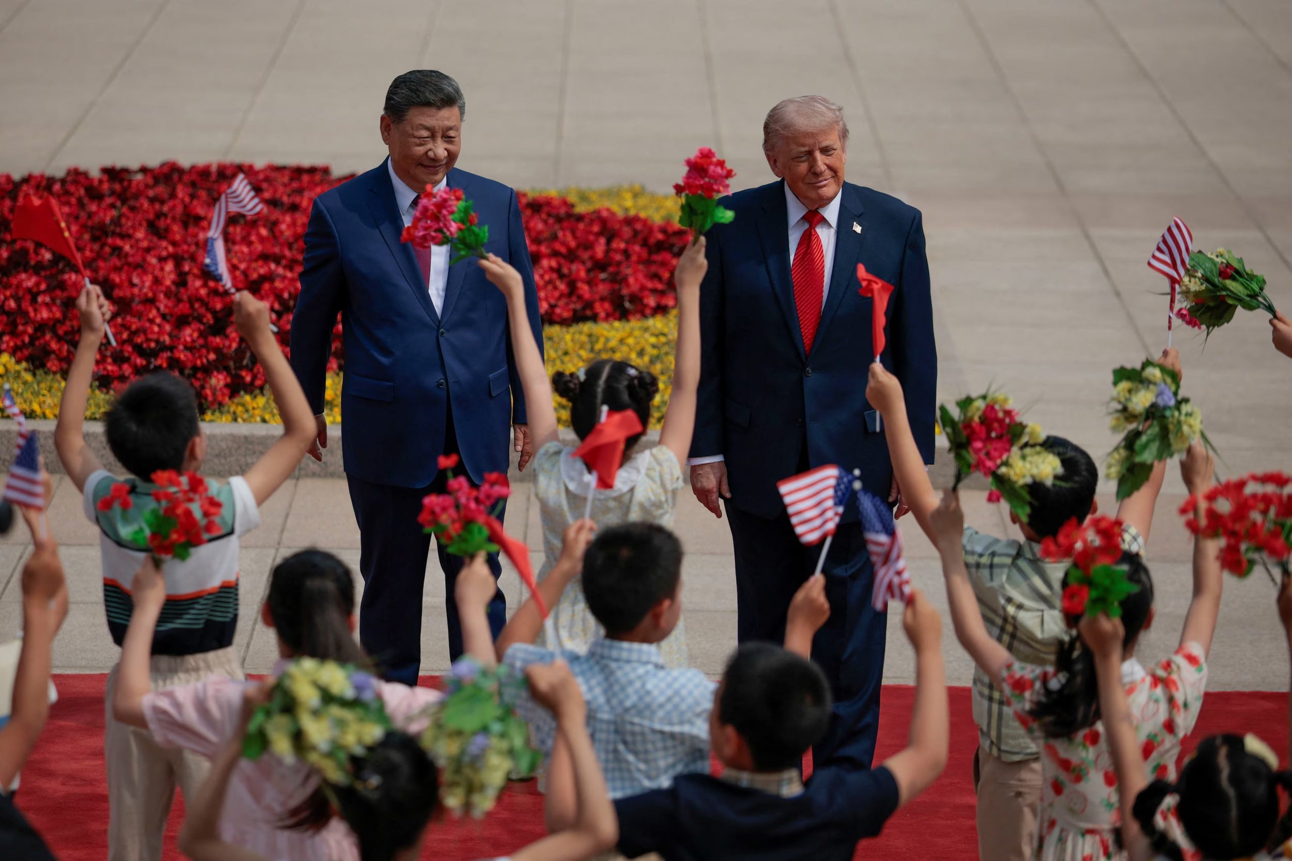 Durante la ceremonia, niños con uniformes escolares y banderas de Estados Unidos y China corearon “¡Bienvenidos, bienvenidos!” mientras ambos mandatarios recorrían la plaza del complejo oficial en Beijing (REUTERS)