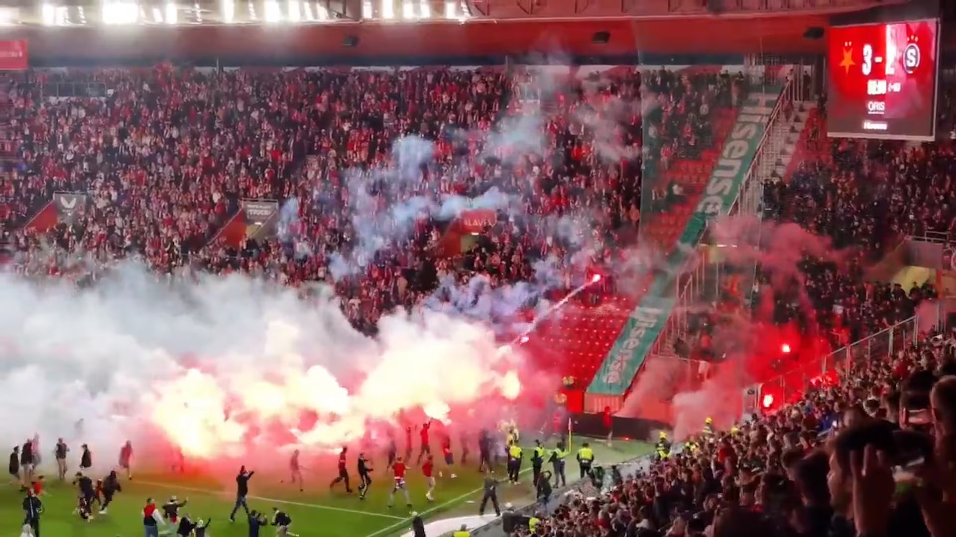 Los aficionados invadieron el campo de juego en medio de humo y bengalas rojas