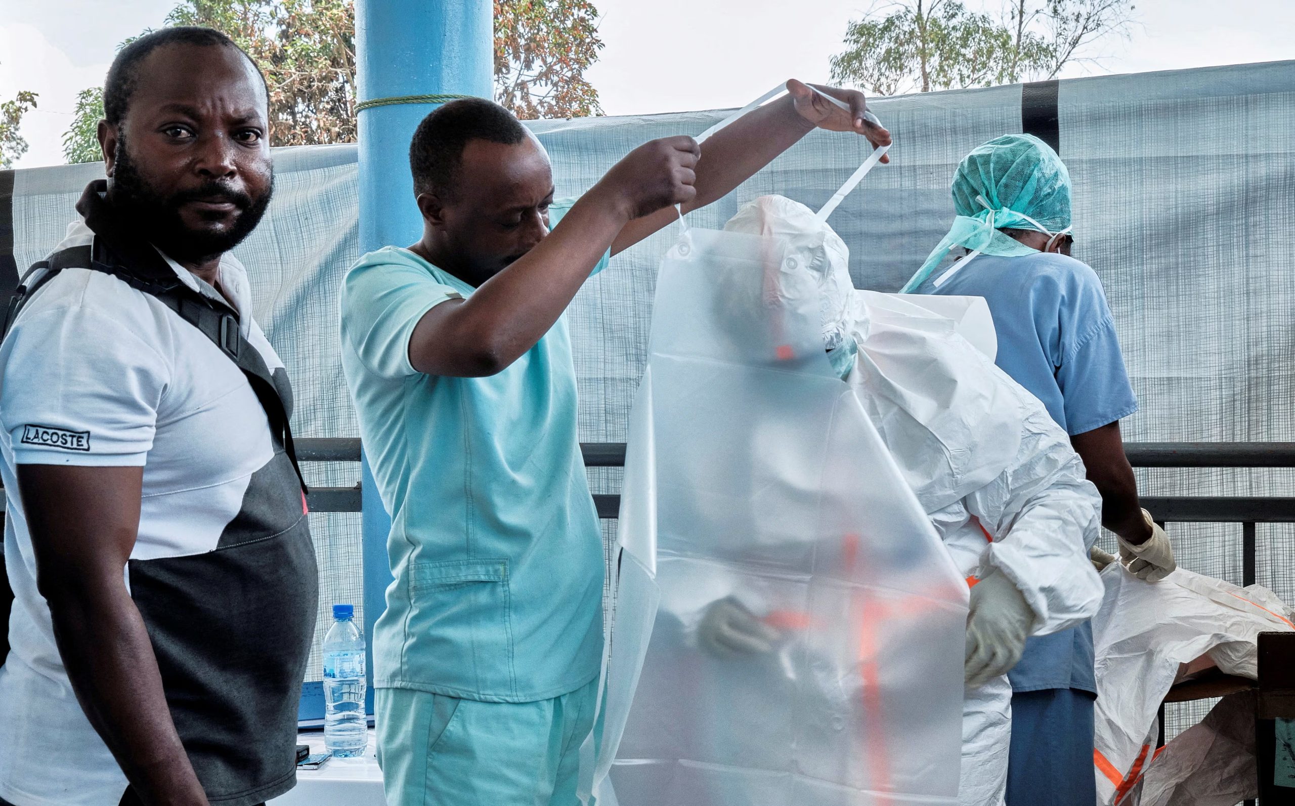 Un equipo médico de la Alianza para la Acción Médica Internacional (ALIMA), una ONG internacional, se equipa con material de protección individual (EPI) mientras instala un centro de tratamiento para la respuesta al ébola. REUTERS/Gradel Muyisa Mumbere/Foto de archivo