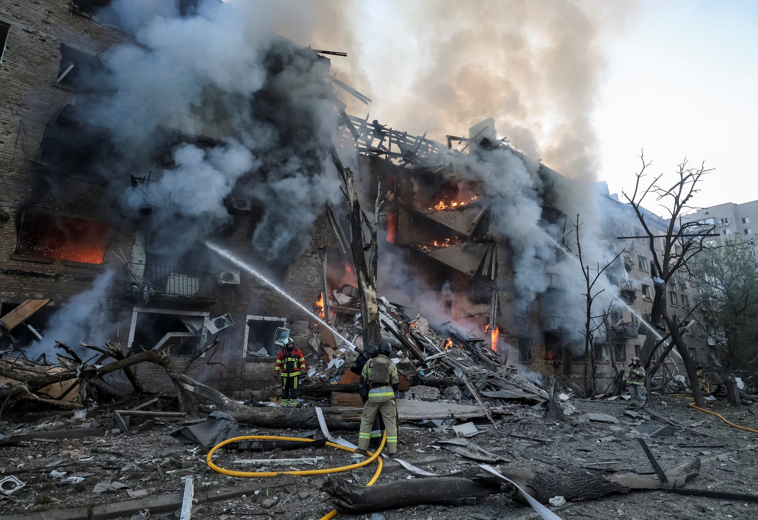 Los bomberos trabajan en el lugar donde un edificio de apartamentos fue destruido por un ataque con misiles y drones rusos.