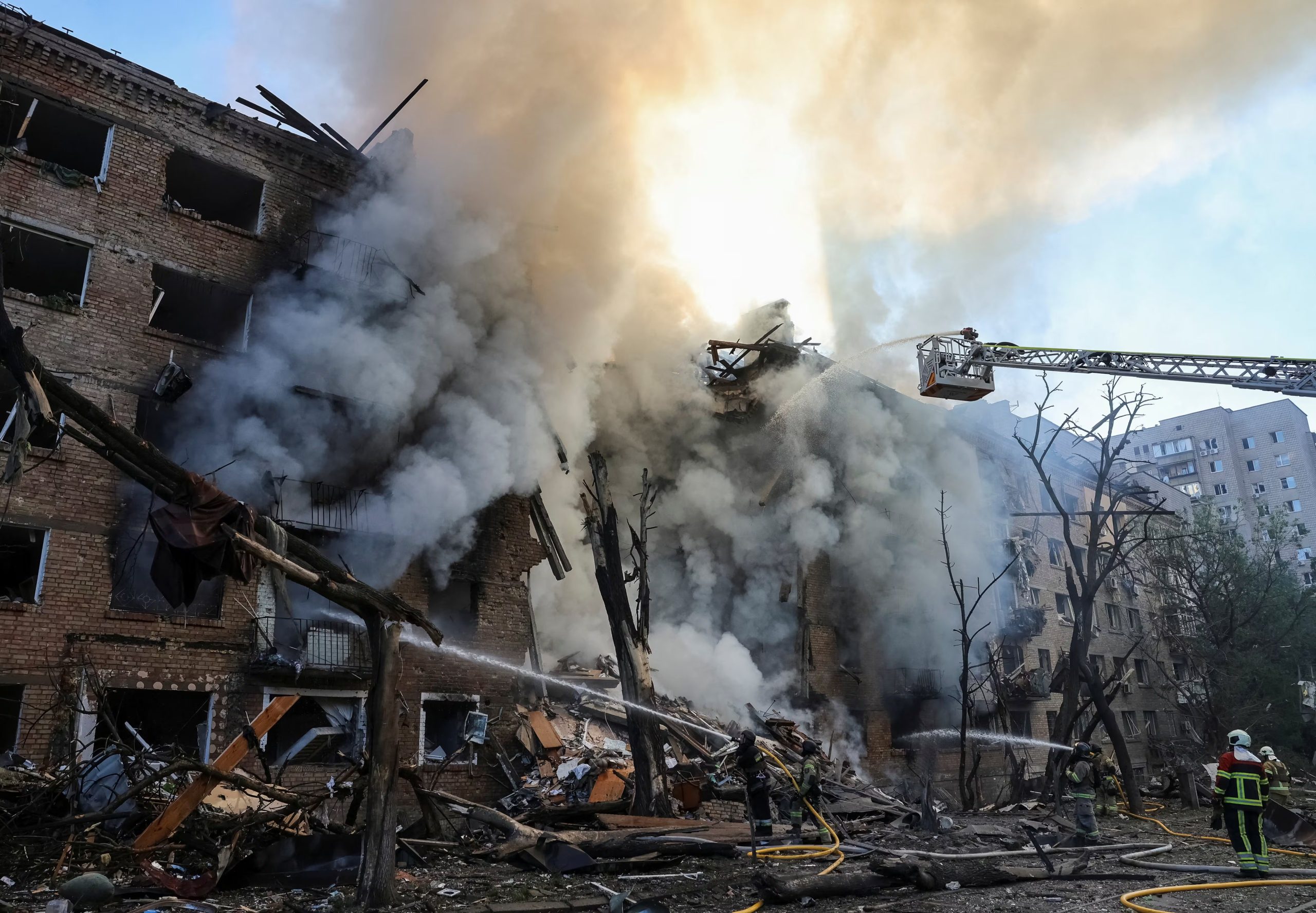 Los bomberos trabajan en el lugar donde un edificio de apartamentos fue destruido por un ataque con misiles y drones rusos.