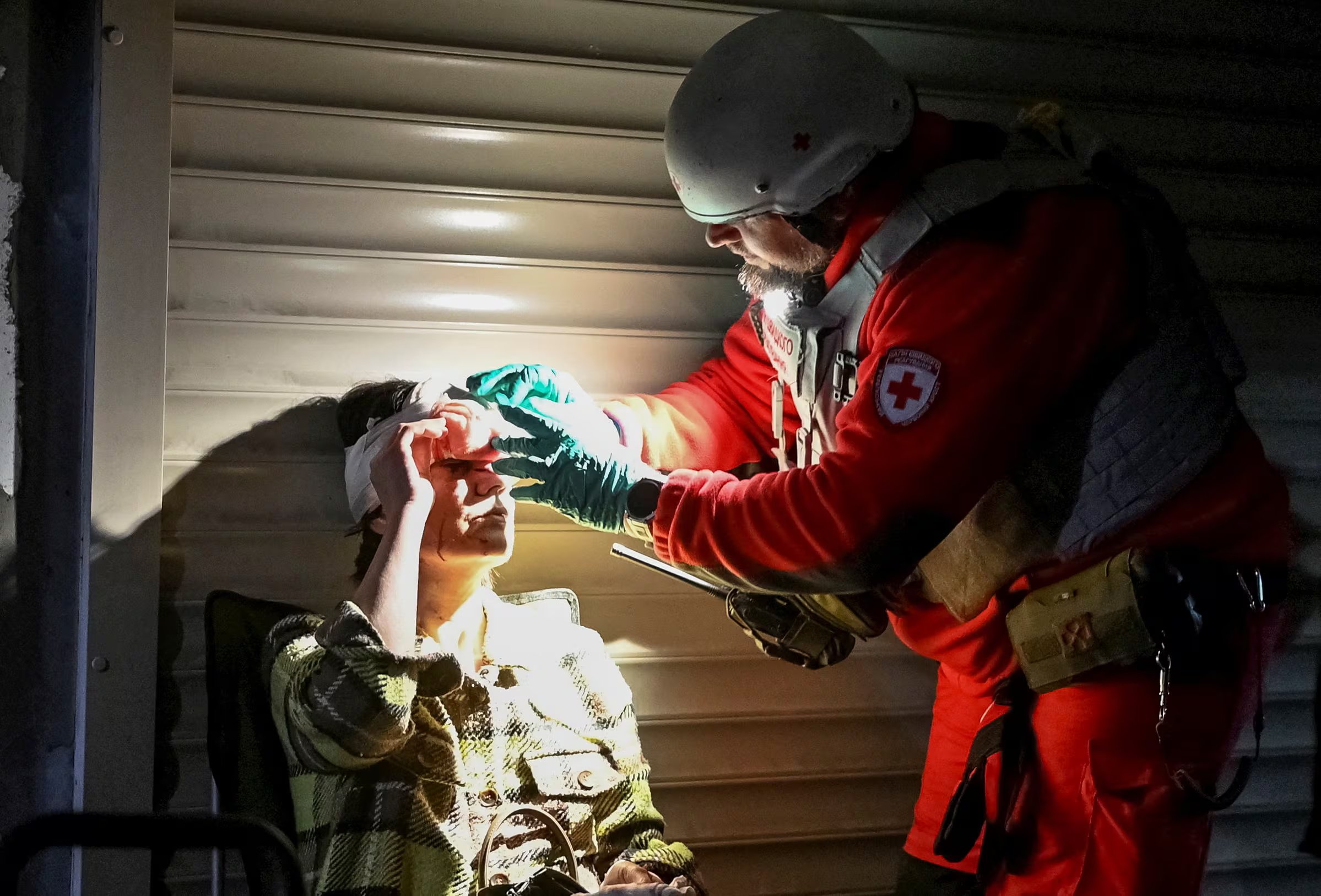 Un trabajador sanitario atiende a un residente herido en un refugio situado en la zona afectada por un ataque con misiles y drones rusos.