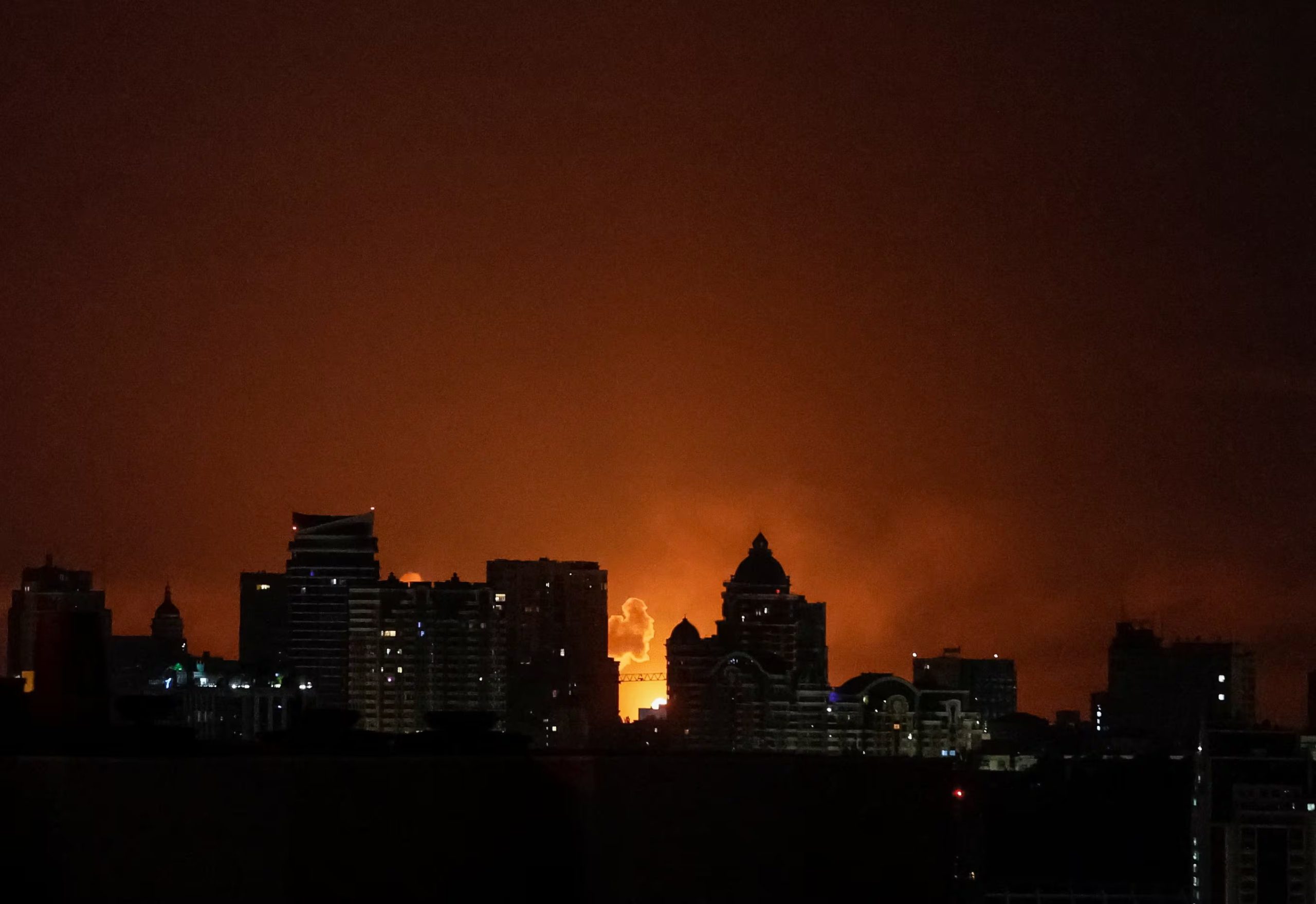 Una explosión ilumina el cielo sobre la ciudad durante un ataque con misiles y drones rusos.