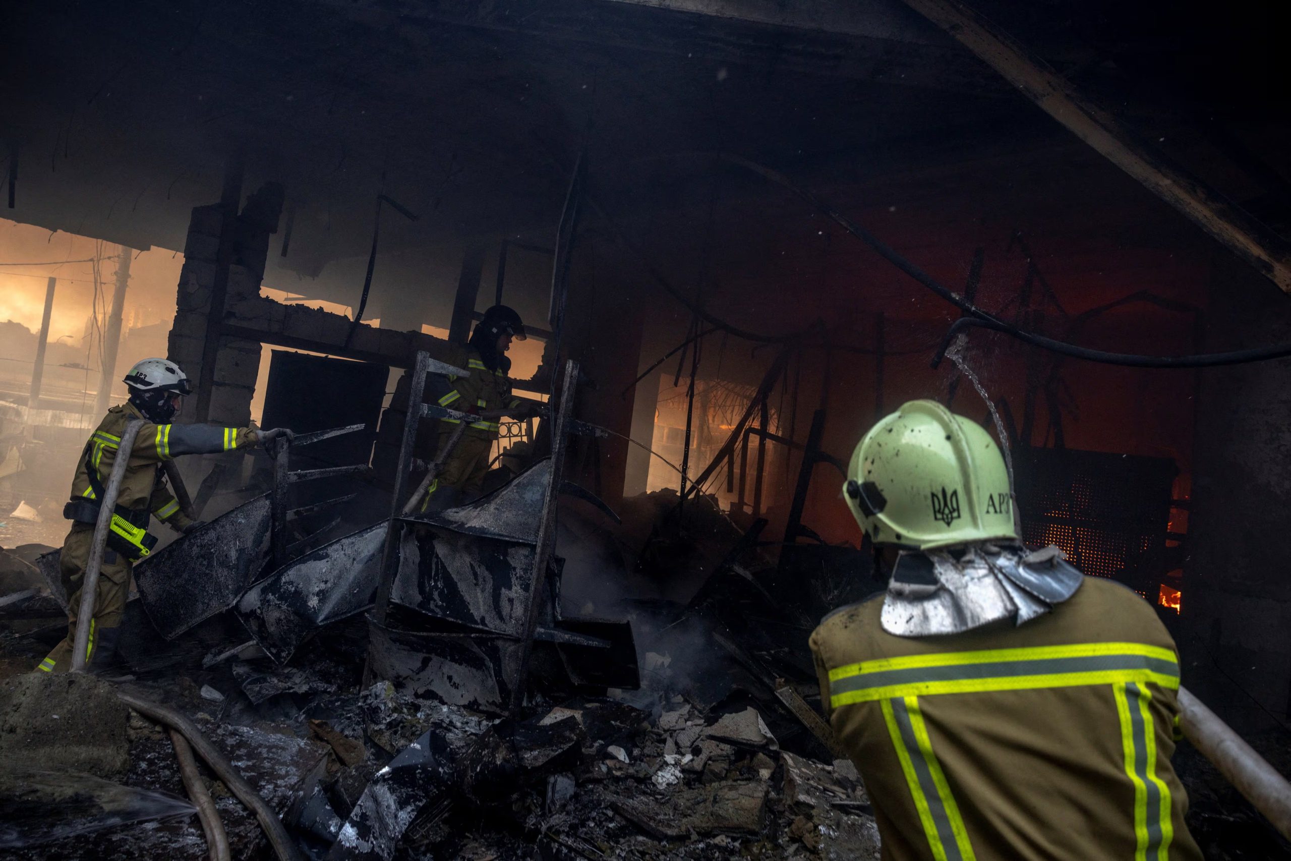 Los bomberos trabajan en el interior de un edificio incendiado durante los ataques nocturnos con misiles y drones rusos.