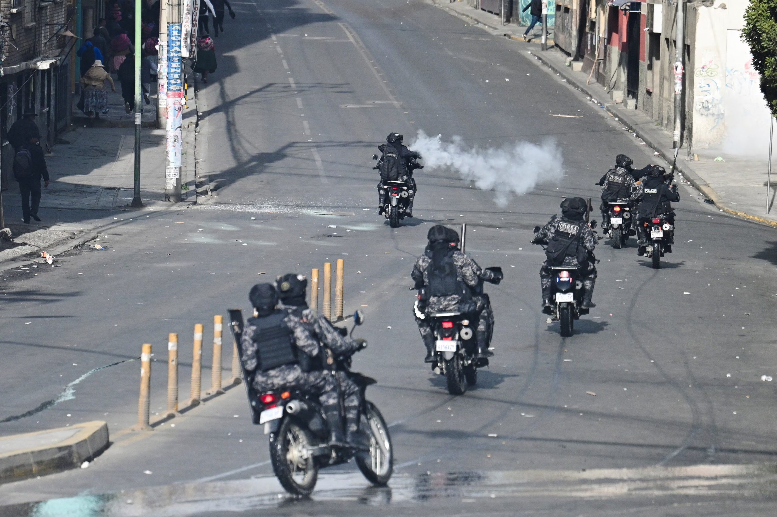 Un agente de policía a bordo de una motocicleta lanza gases lacrimógenos contra manifestantes durante una marcha que exige la renuncia del presidente de Bolivia, Rodrigo Paz, mientras la crisis económica y de combustible del país se agrava debido a la escasez de dólares estadounidenses y la caída de la producción nacional de energía, en La Paz, Bolivia, el 18 de mayo de 2026. REUTERS/Claudia Morales