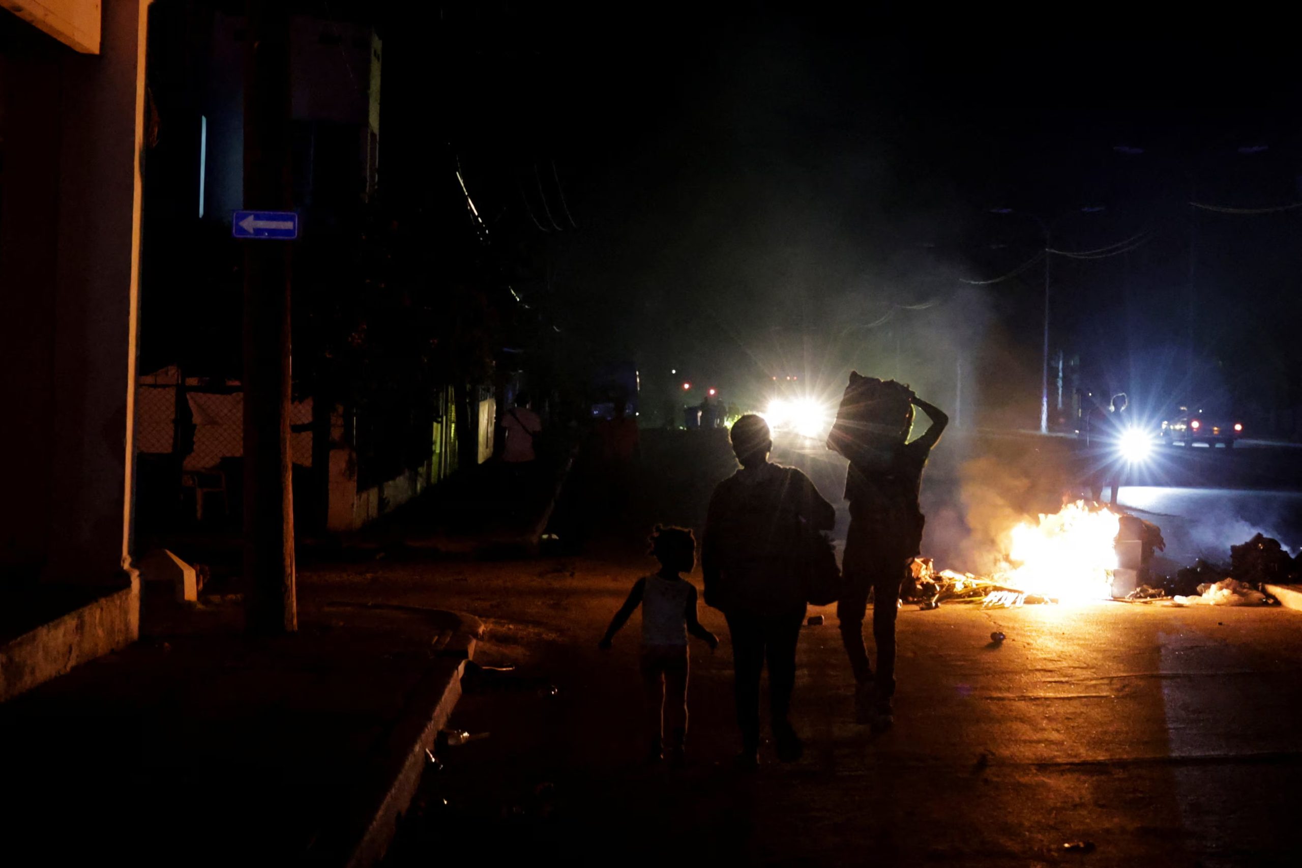 Un grupo de personas pasa junto a la basura prendida fuego en medio de una calle durante una protesta contra los frecuentes cortes de electricidad en La Habana, Cuba. 13 de mayo de 2026 (REUTERS/Norlys Pérez)