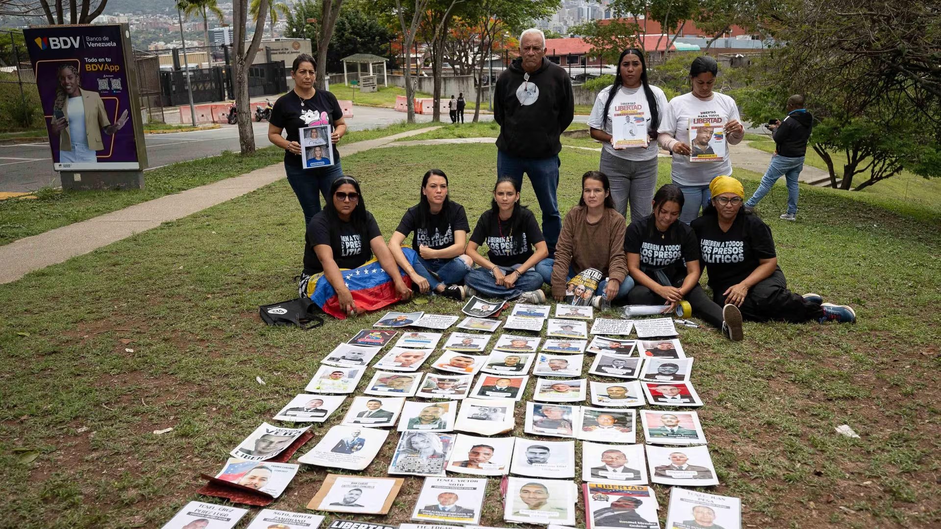 Familiares de presos políticos aguardan con carteles este lunes, en las inmediaciones de la Embajada de Estados Unidos en Caracas (EFE/Ronald Peña)