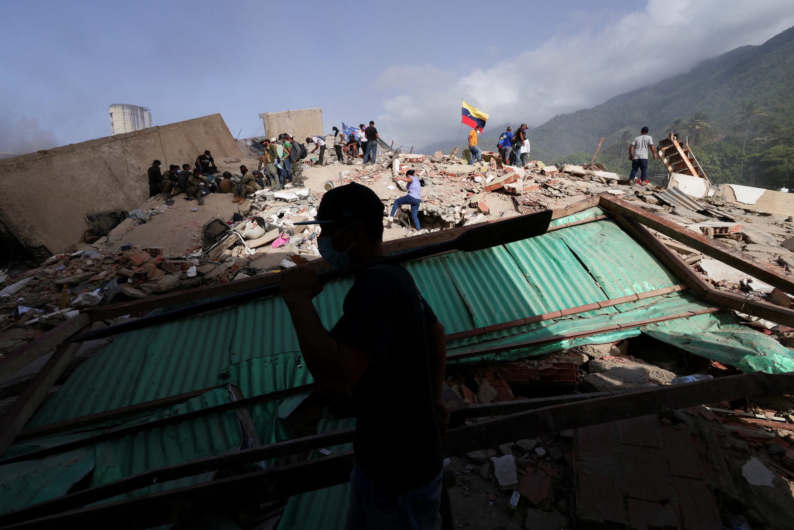 Rescatistas y otros equipos trabajan para sacar a personas de entre los escombros de un edificio derrumbado tras los terremotos que azotaron el país, en La Guaira, Venezuela, 26 de junio de 2026. REUTERS/Gaby Oraa