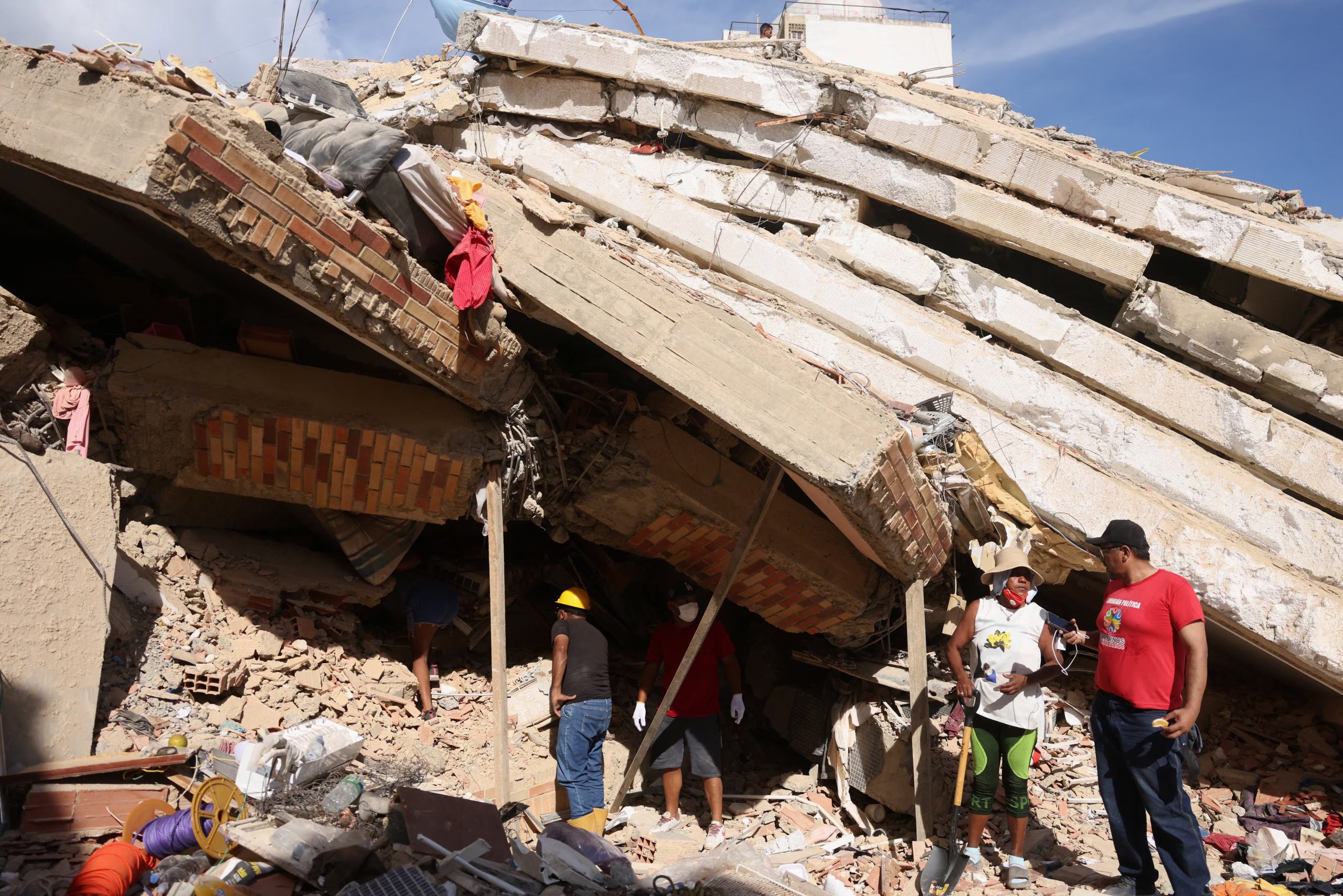 Personas trabajan en el rescate de víctimas entre los escombros de un edificio destruido, tras los terremotos que azotaron el país, en el barrio de Tanaguarena, La Guaira, Venezuela, 28 de junio de 2026. REUTERS/Leonardo Fernández Viloria