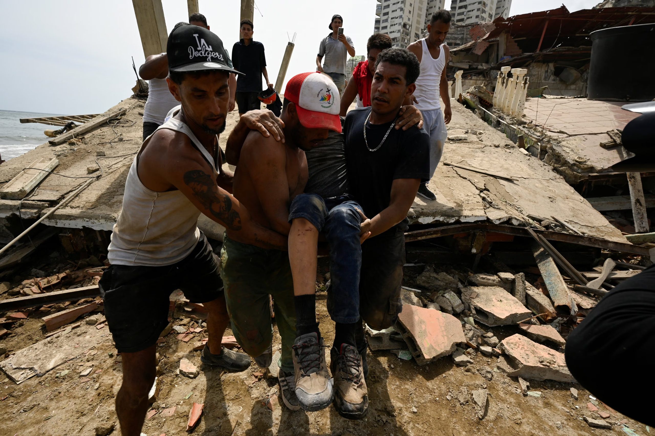 Un grupo de personas transporta a un hombre herido tras los terremotos ocurridos en La Guaira, Venezuela (REUTERS / Maxwell Briceno)