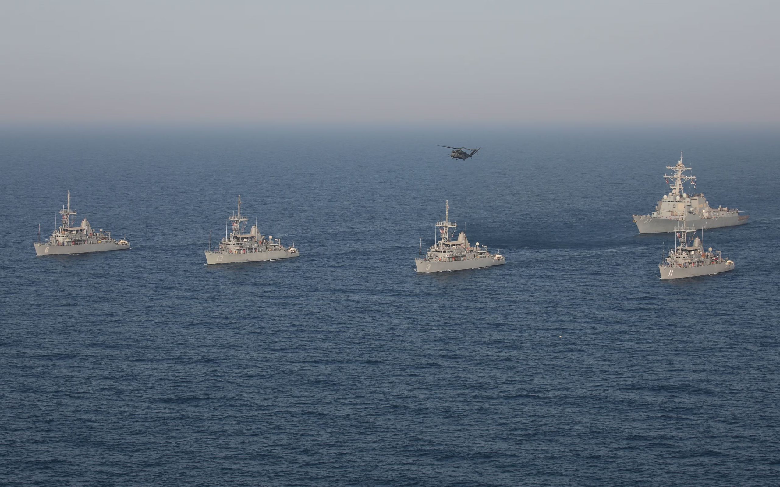 Una formación de buques de contramedidas de minas de la clase Avenger, el USS Devastator (MCM 6), el USS Gladiator (MCM 11), el USS Sentry (MCM 3), el USS Dextrous (MCM 13), el destructor de misiles guiados de la clase Arleigh Burke USS Mason (DDG 87) y un helicóptero MH-53E Sea Dragon asignado al Escuadrón de Helicópteros de Contramedidas de Minas (HSM) 15, conocido como los 