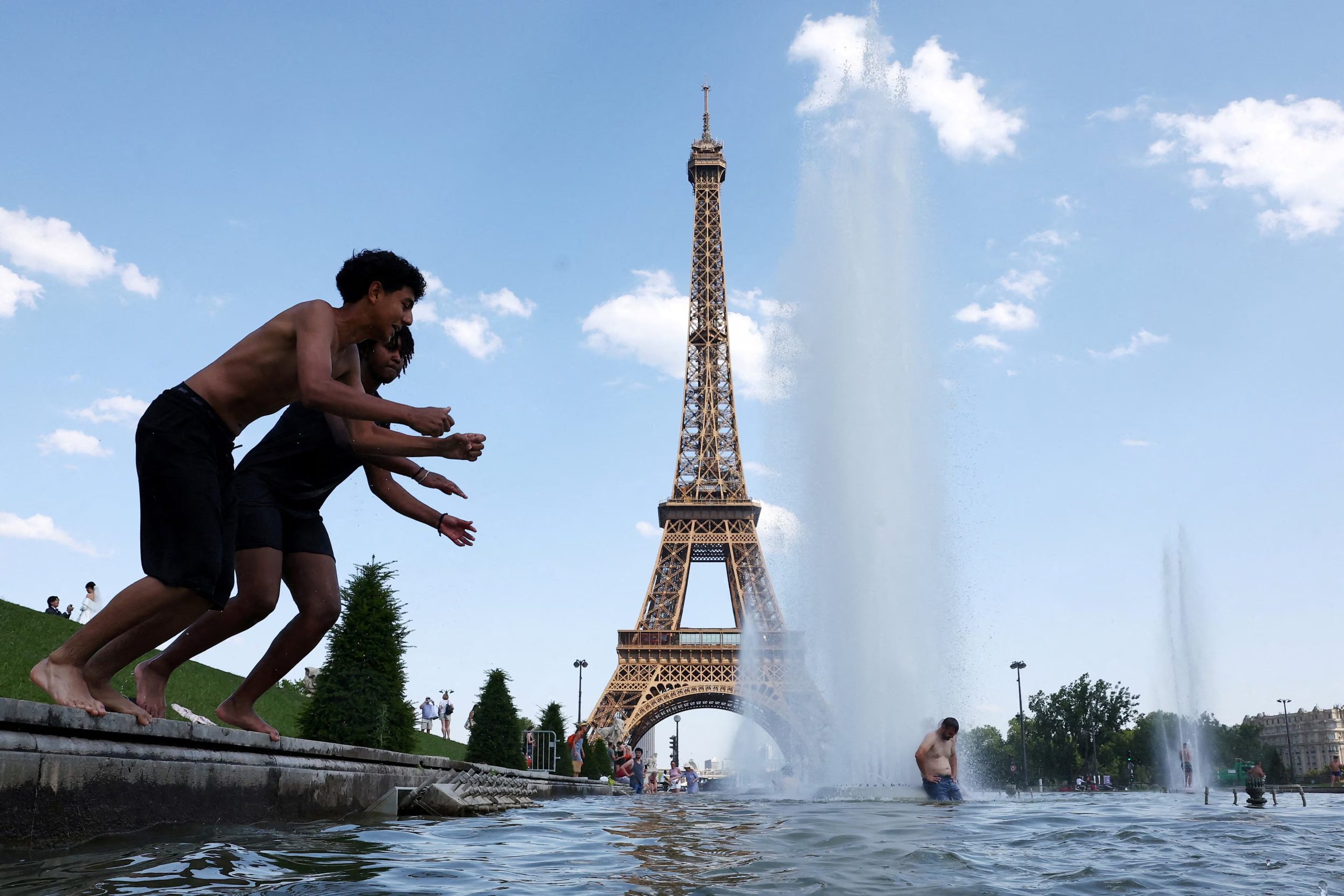 La gente se refresca en la fuente del Trocadero, junto a la Torre Eiffel de París, mientras suben las temperaturas durante una ola de calor que afecta a gran parte de Francia, el 22 de junio de 2026. REUTERS/Abdul Saboor 