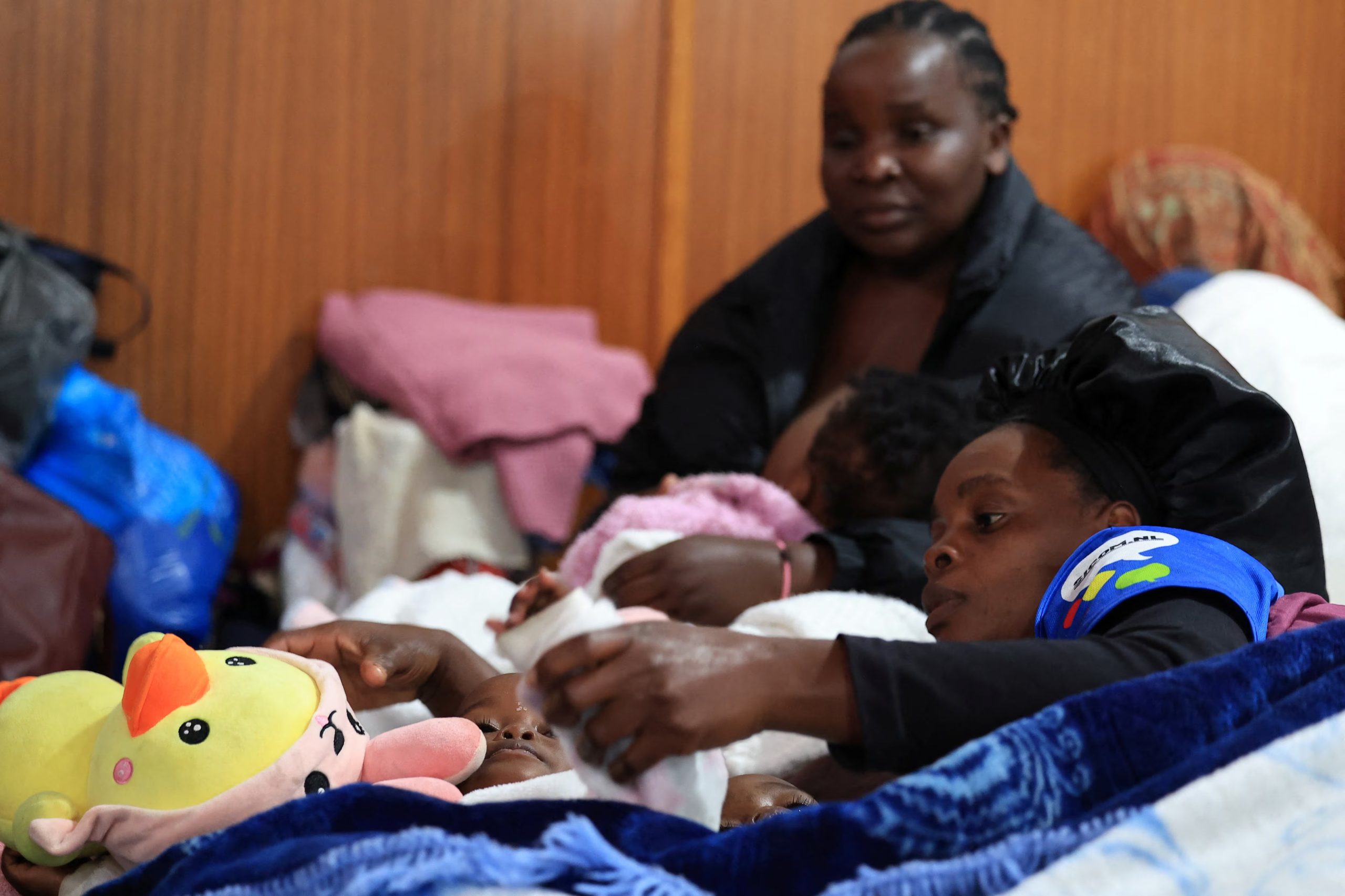 Una migrante desplazada junto a sus hijos en Kleinmond, Sudáfrica, el 3 de junio de 2026. (REUTERS/Esa Alexander)