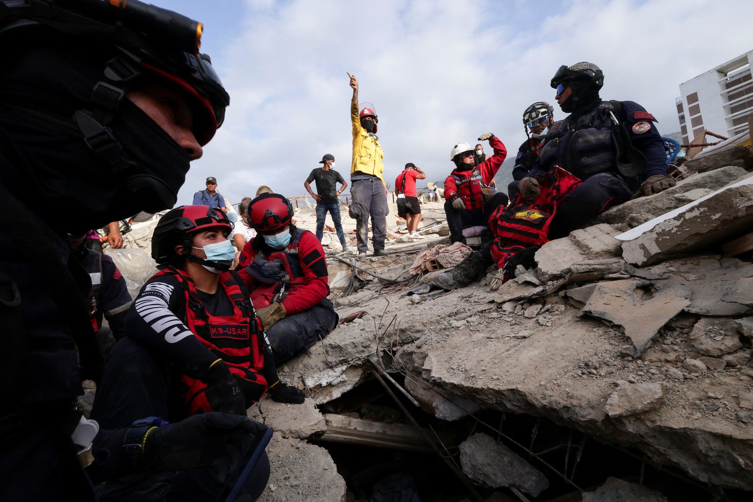 Personal de emergencia y otras personas trabajan para rescatar a individuos de entre los escombros de un edificio colapsado tras los terremotos que afectaron al país, en La Guaira, Venezuela, el 26 de junio de 2026 (REUTERS/Gaby Oraa)