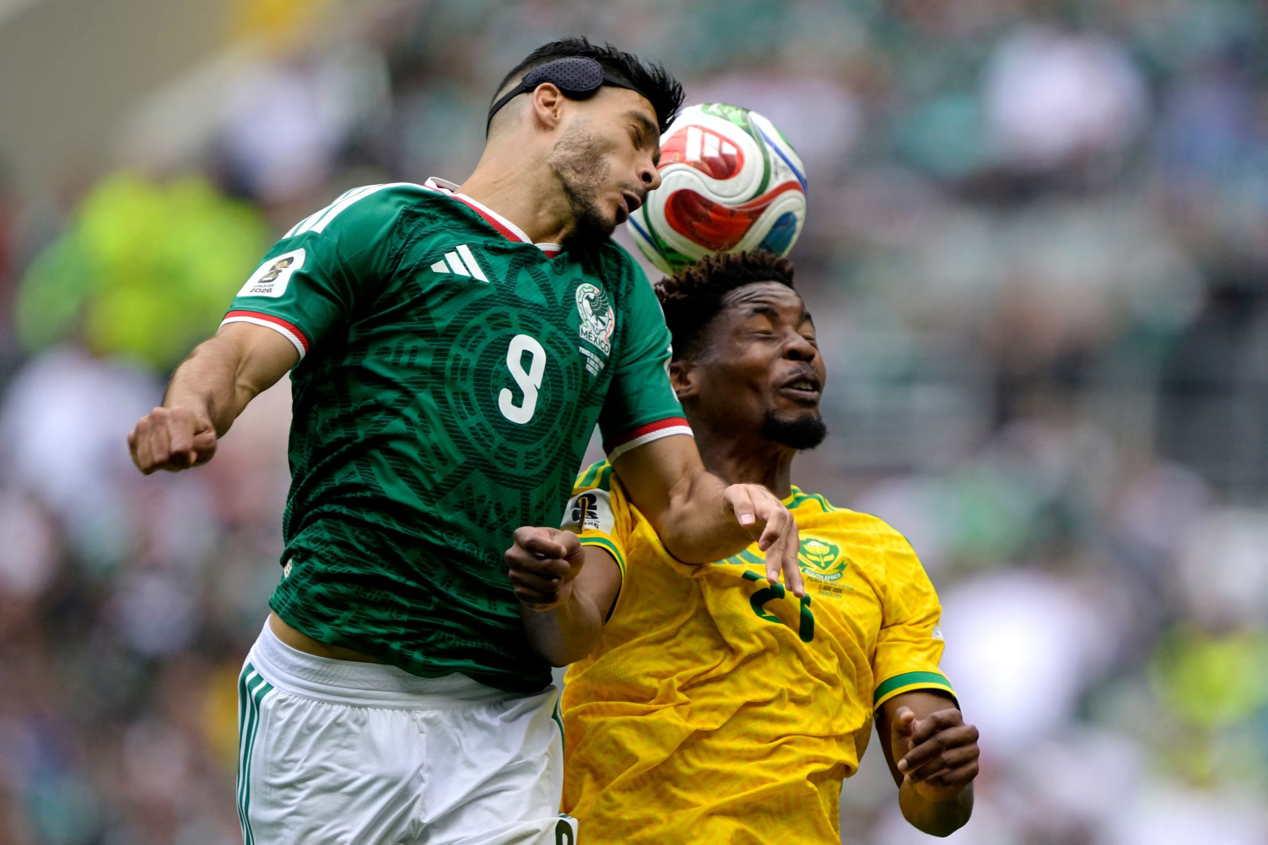 El delantero mexicano Raúl Jiménez (n.º 09) y el defensa sudafricano Ime Okon (n.º 21) luchan por el balón durante el partido de fútbol del Grupo A del Mundial 2026 entre México y Sudáfrica en el Estadio Ciudad de México, el 11 de junio de 2026. (Foto de Alfredo ESTRELLA / AFP)