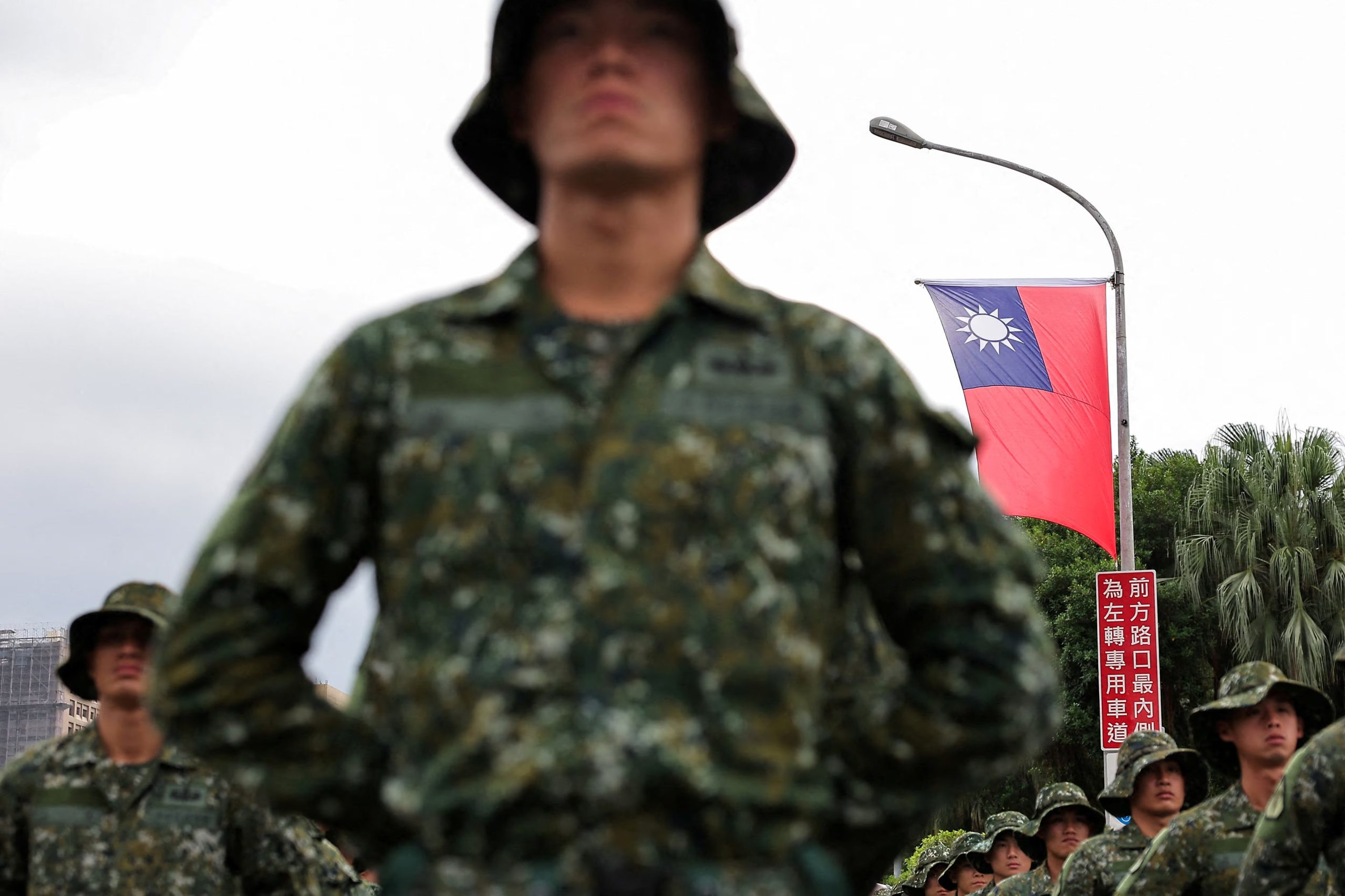 Una bandera de Taiwán ondea mientras soldados se preparan para celebrar el Día Nacional, que conmemora el 113° aniversario de la República de China, nombre oficial de la isla, en Taipéi (REUTERS/Ann Wang).
