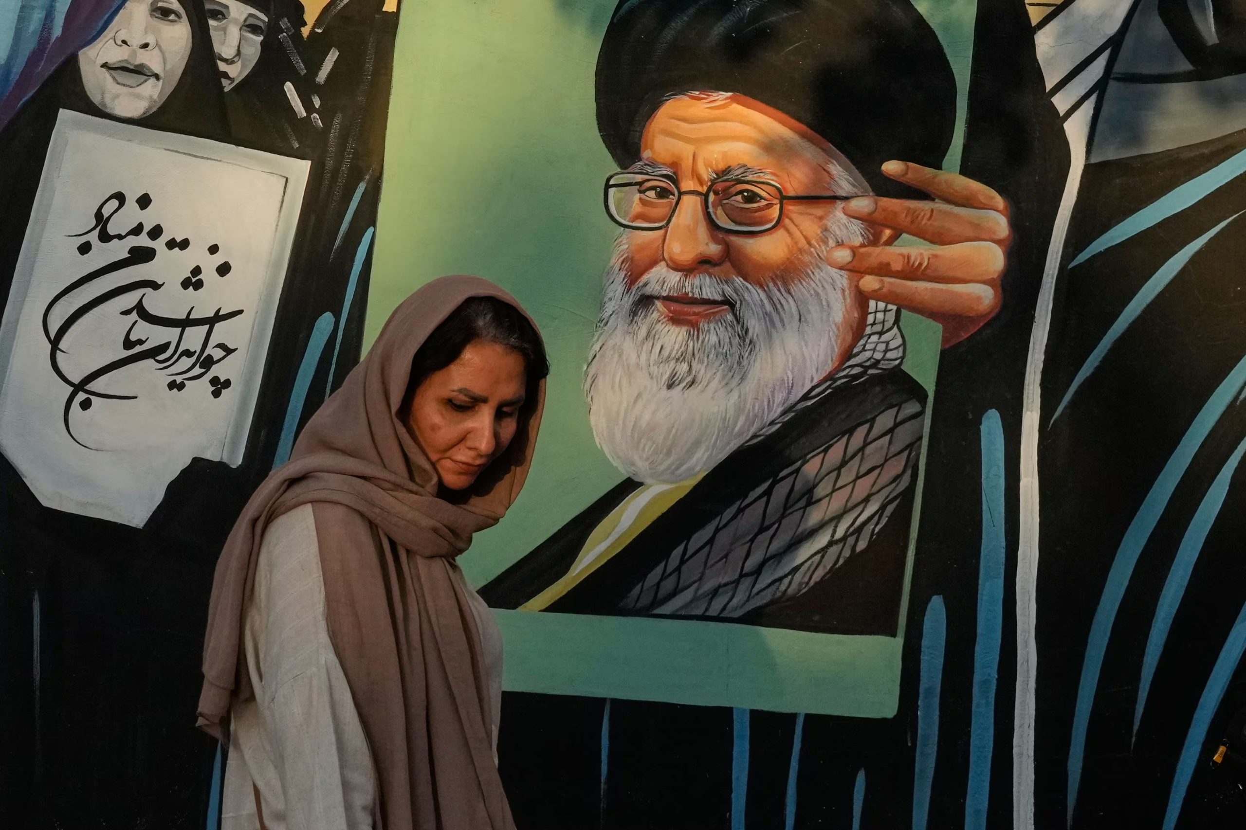 Una mujer al lado de un mural con el retrato del ex líder supremo iraní Ali Khamenei, en Teherán, el 18 de julio del 2026 (AP foto/Vahid Salemi)