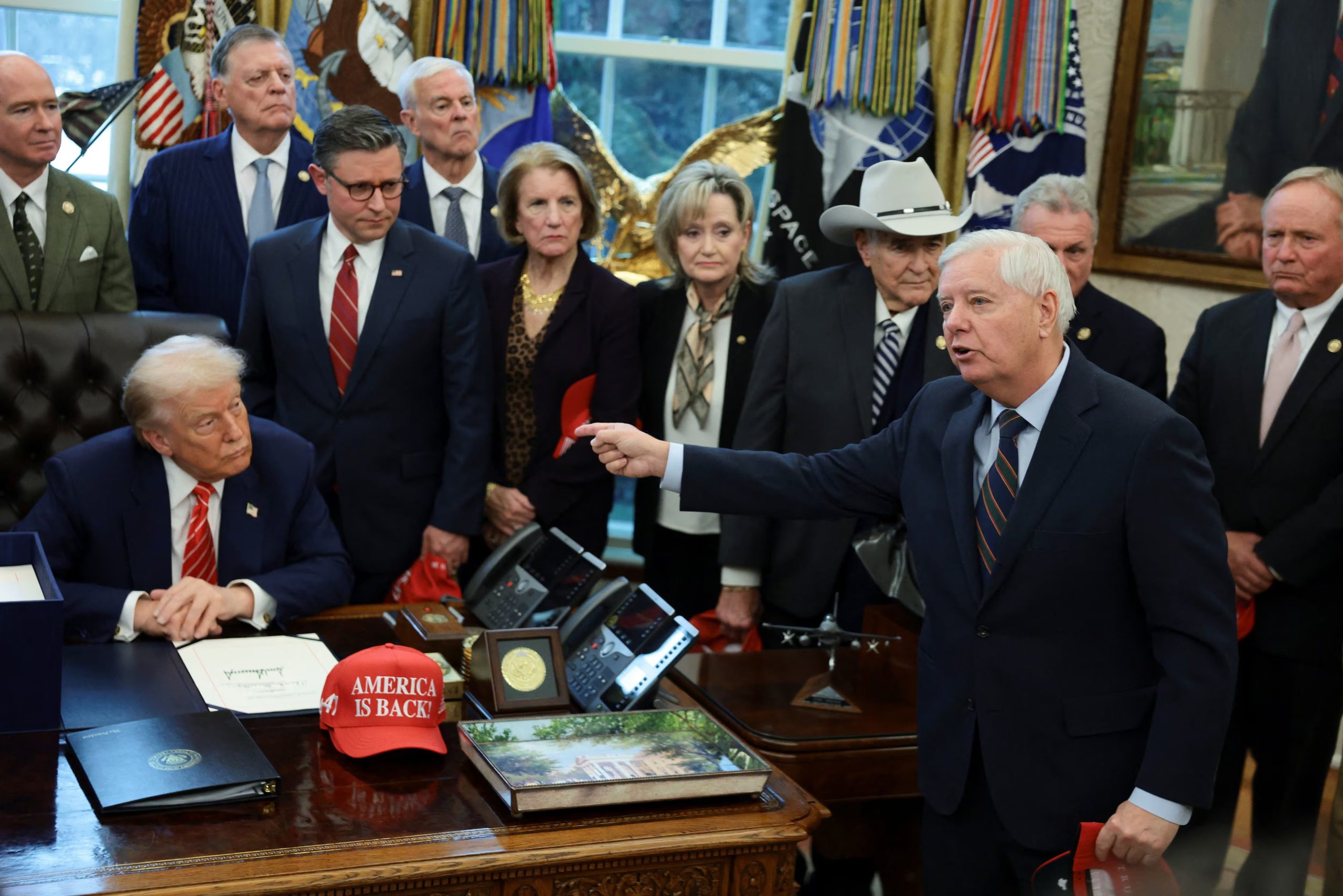 U.S. President Donald Trump sits behind a bill he signed to end the partial government shutdown, as U.S. Senator Lindsey Graham (R-SC) points while he speaks at the White House in Washington, D.C., U.S., February 3, 2026. REUTERS/Evelyn Hockstein