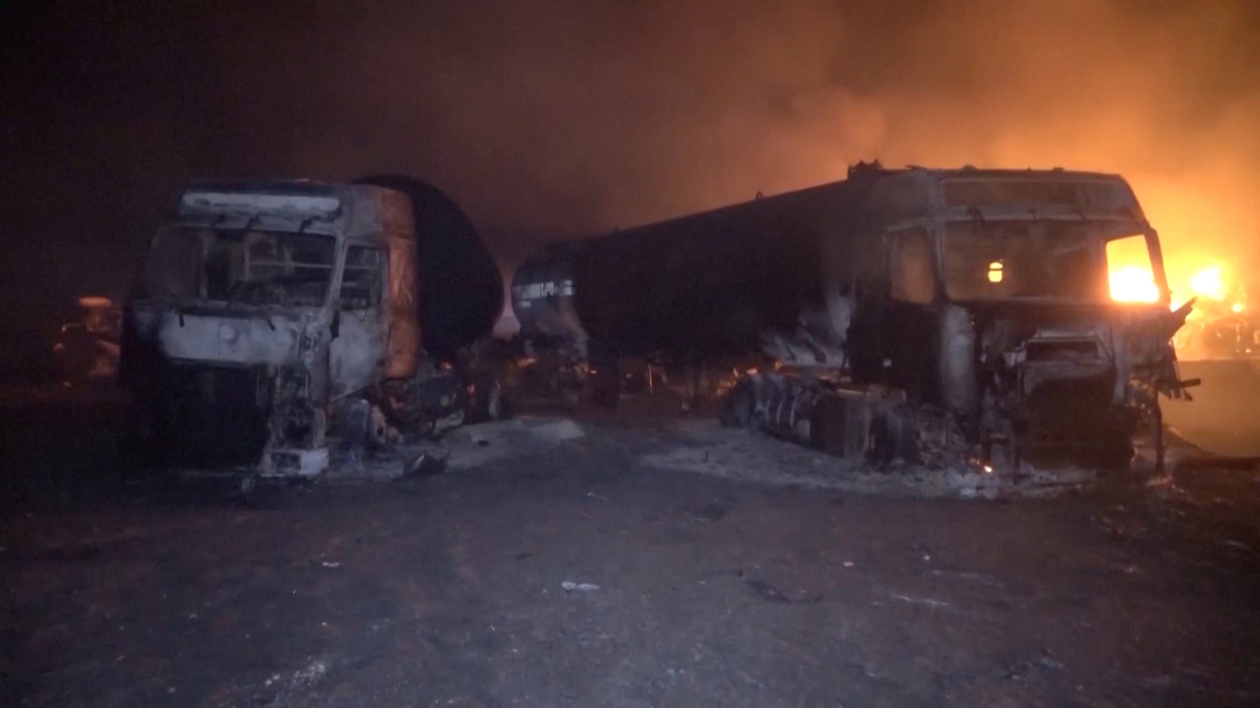 Fuego y humo se elevan junto a vehículos calcinados tras, según informó Al Masirah TV, un ataque estadounidense contra el puerto de combustible de Ras Isa, Yemen (Al-Masirah TV/Distribuido vía REUTERS)
