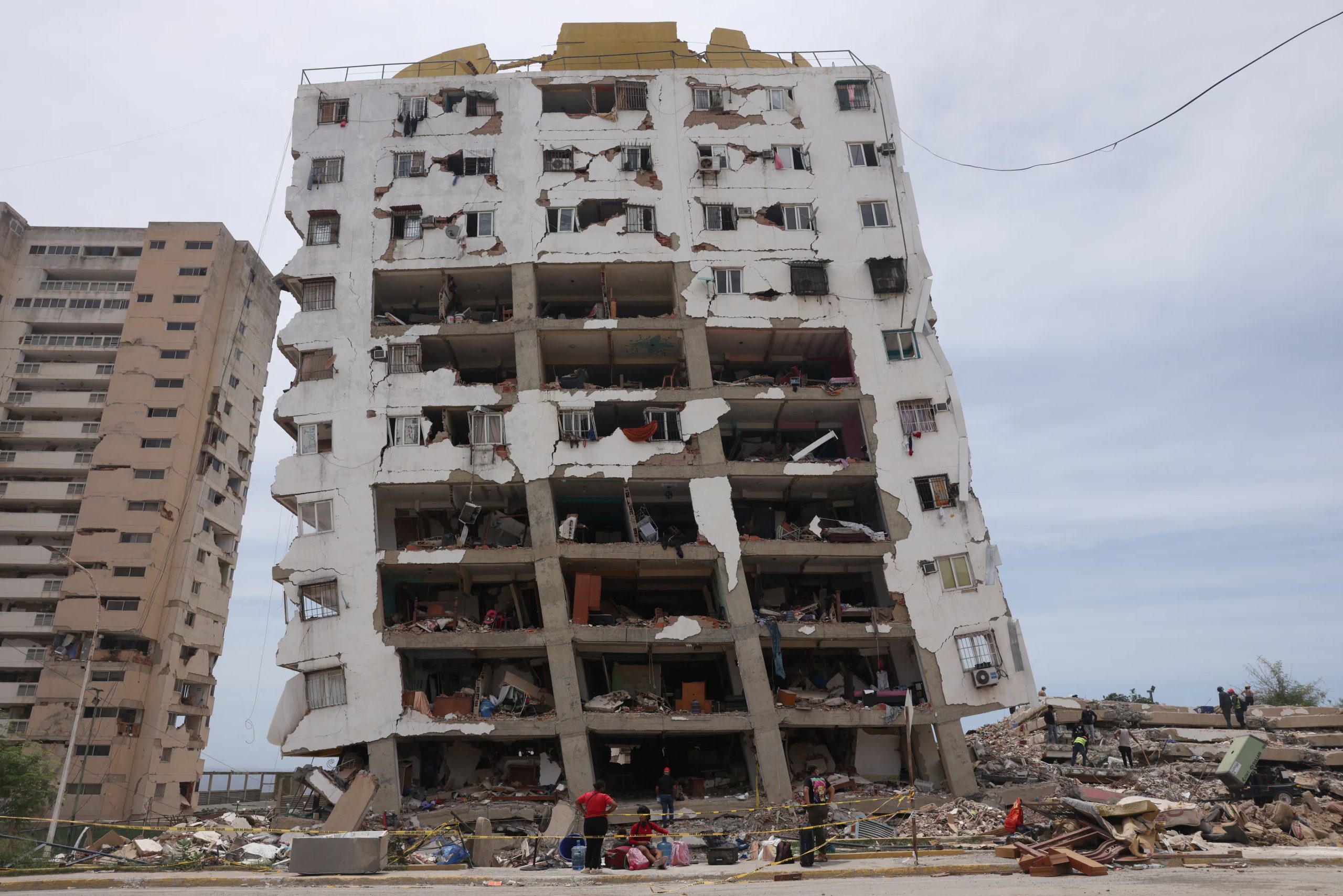 Una familia reúne sus pertenencias frente a un edificio de la Gran Misión Vivienda Venezuela dañado por los terremotos del 24 de junio, en Catia La Mar (REUTERS/Leonardo Fernandez Viloria)