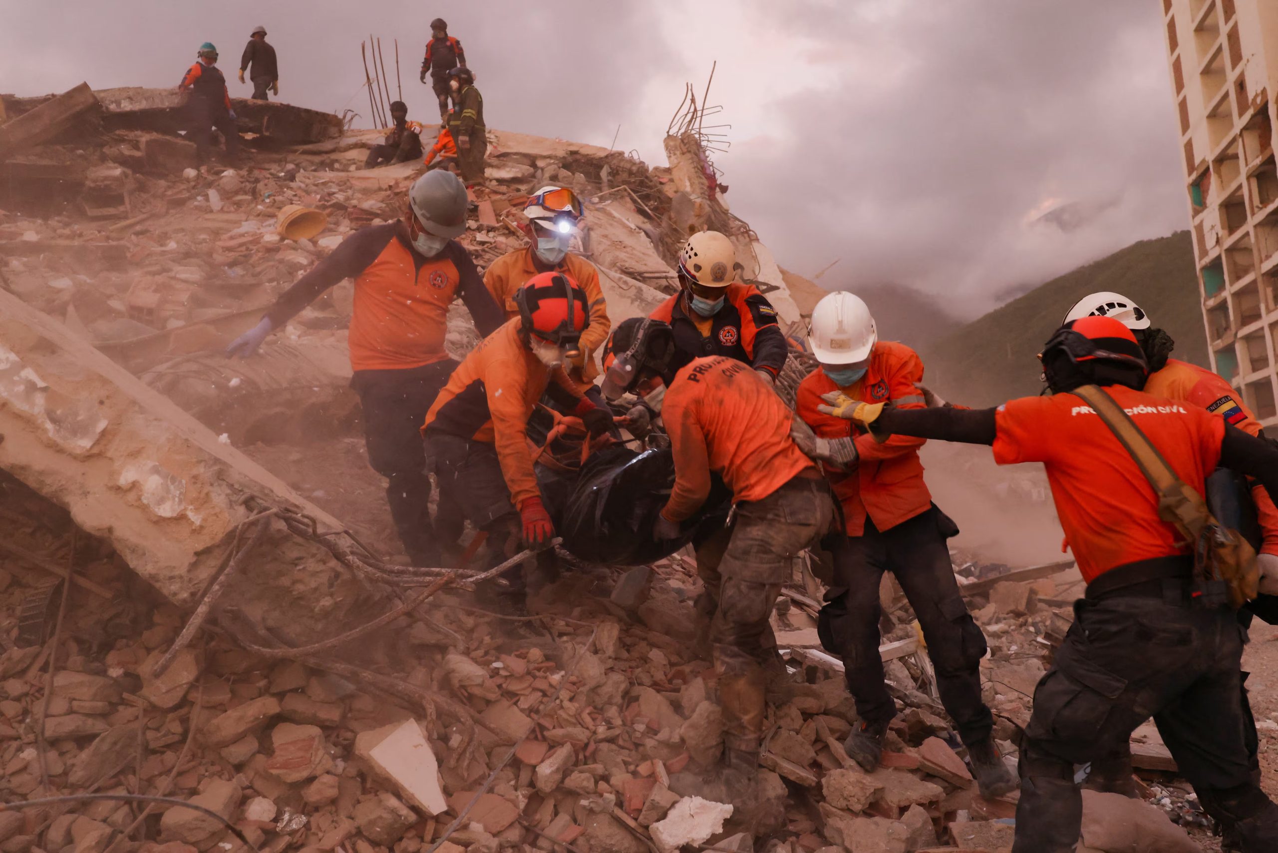 Equipos de rescate trasladan una bolsa con el cuerpo de una víctima entre los escombros de un edificio colapsado (REUTERS/Pablo Sanhueza)
