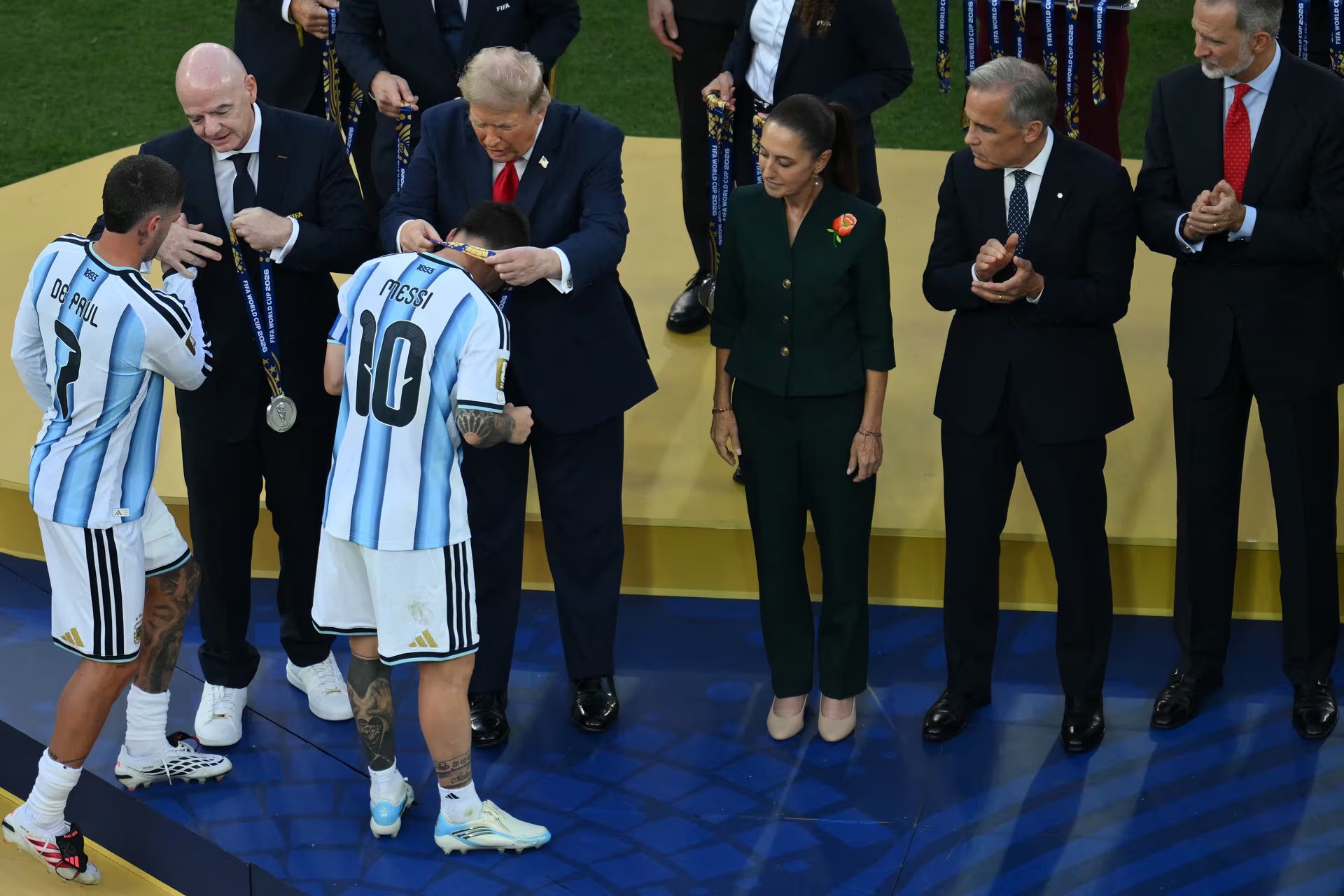 El centrocampista argentino Rodrigo De Paul (izq.) y el delantero argentino Lionel Messi (n.° 10) reciben las medallas de plata de manos del presidente de la FIFA, Gianni Infantino, y del presidente de Estados Unidos, Donald Trump (der.), durante la ceremonia de clausura tras la final del Mundial de Fútbol de 2026 