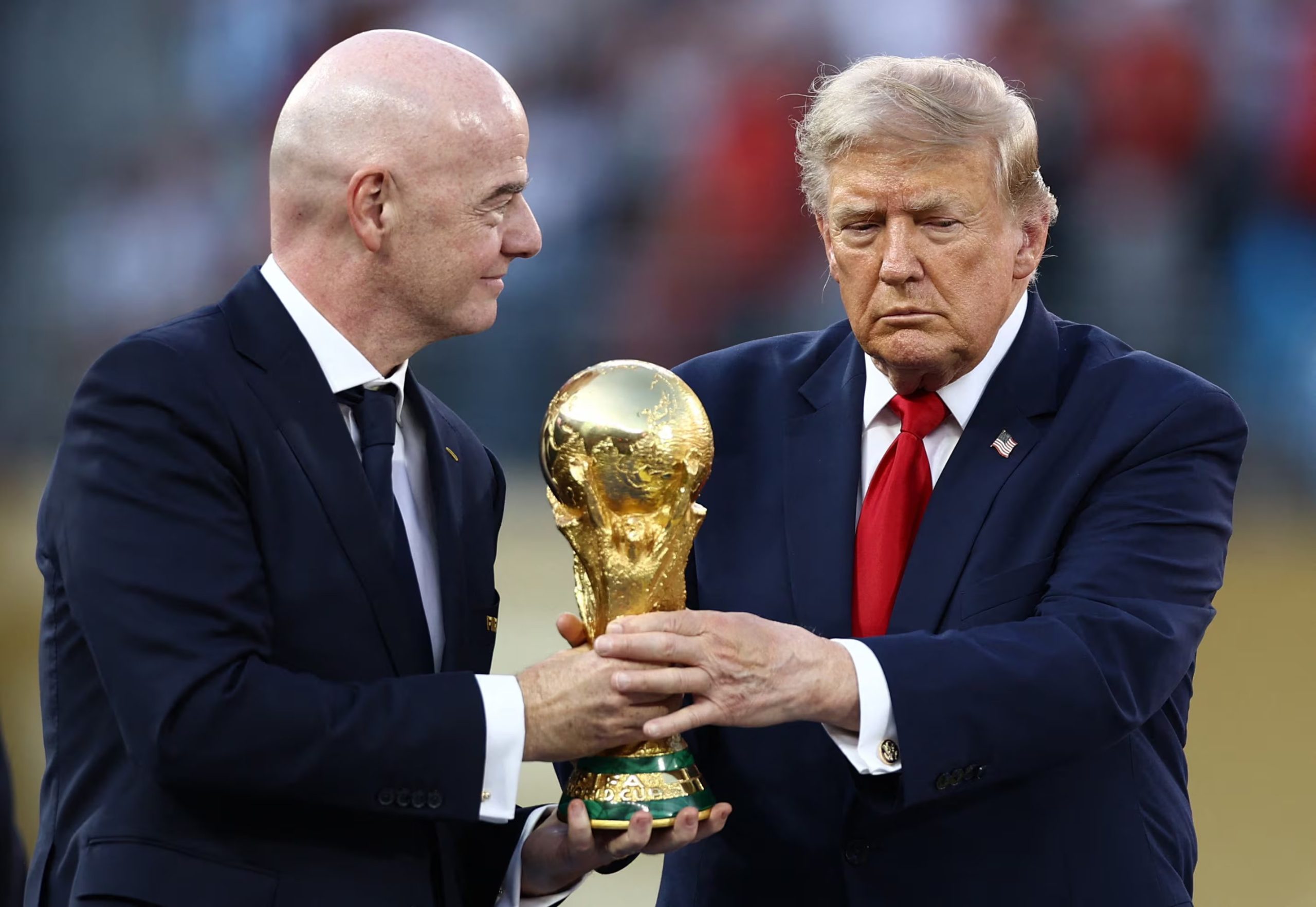 Trump e Infantino llevan la copa momentos antes de entregarla al capitán de España

