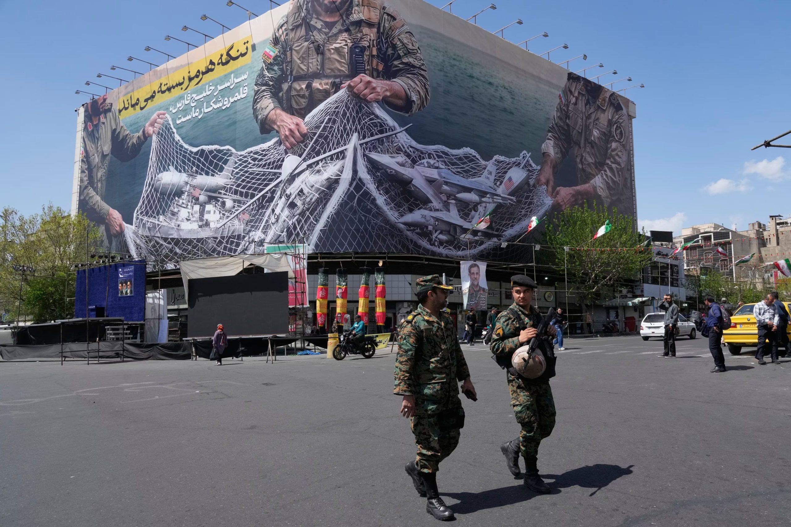 Dos policías pasan adelante de un cartel antiestadounidense en Teherán, Irán (AP Foto/Vahid Salemi/Archivo)