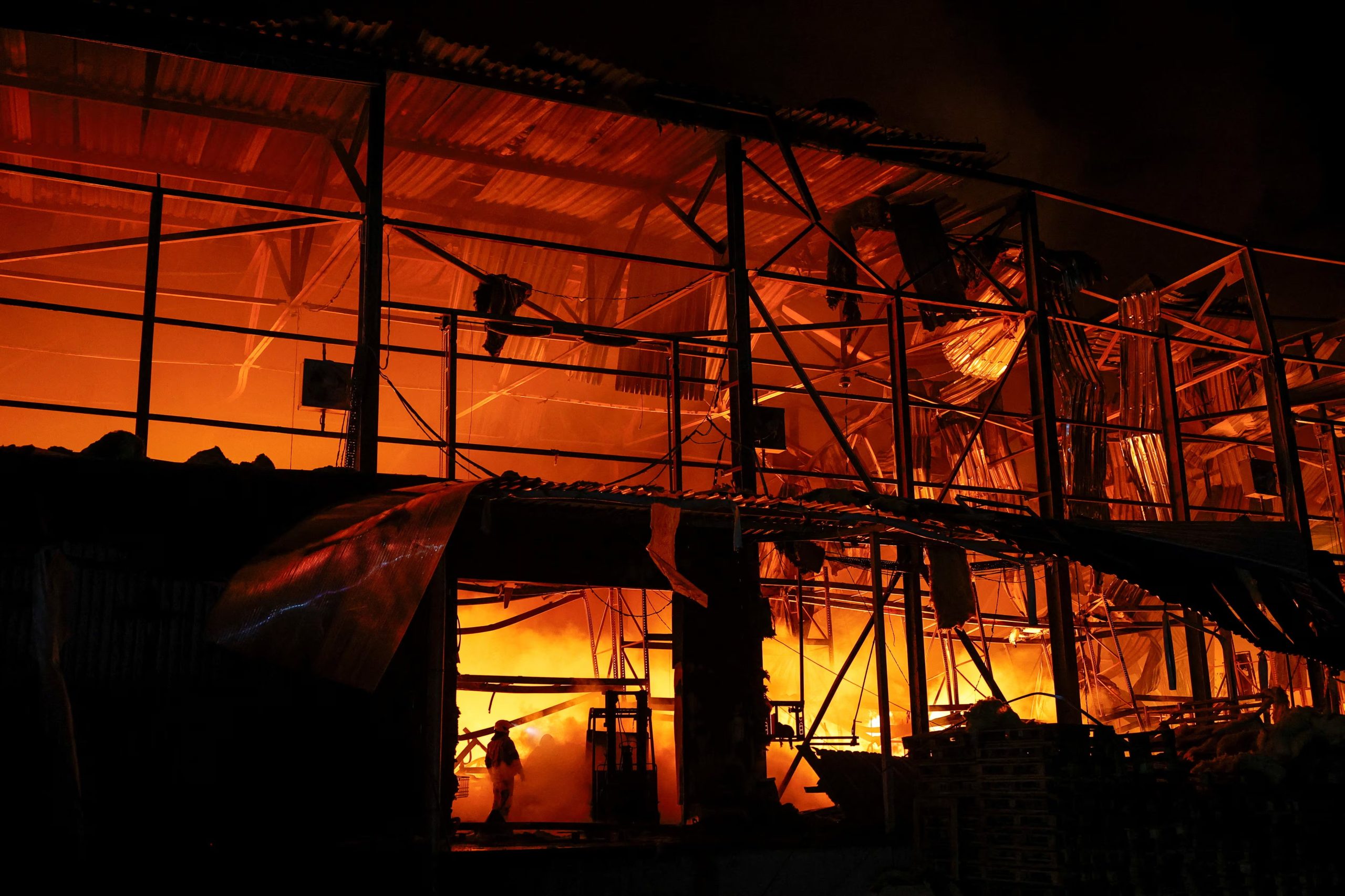 Los bomberos trabajan en el recinto de un almacén dañado durante los ataques con misiles rusos, en el marco de la invasión de Ucrania por parte de Rusia, en Kiev (Ucrania), el 16 de julio de 2026 (REUTERS/Valentyn Ogirenko)