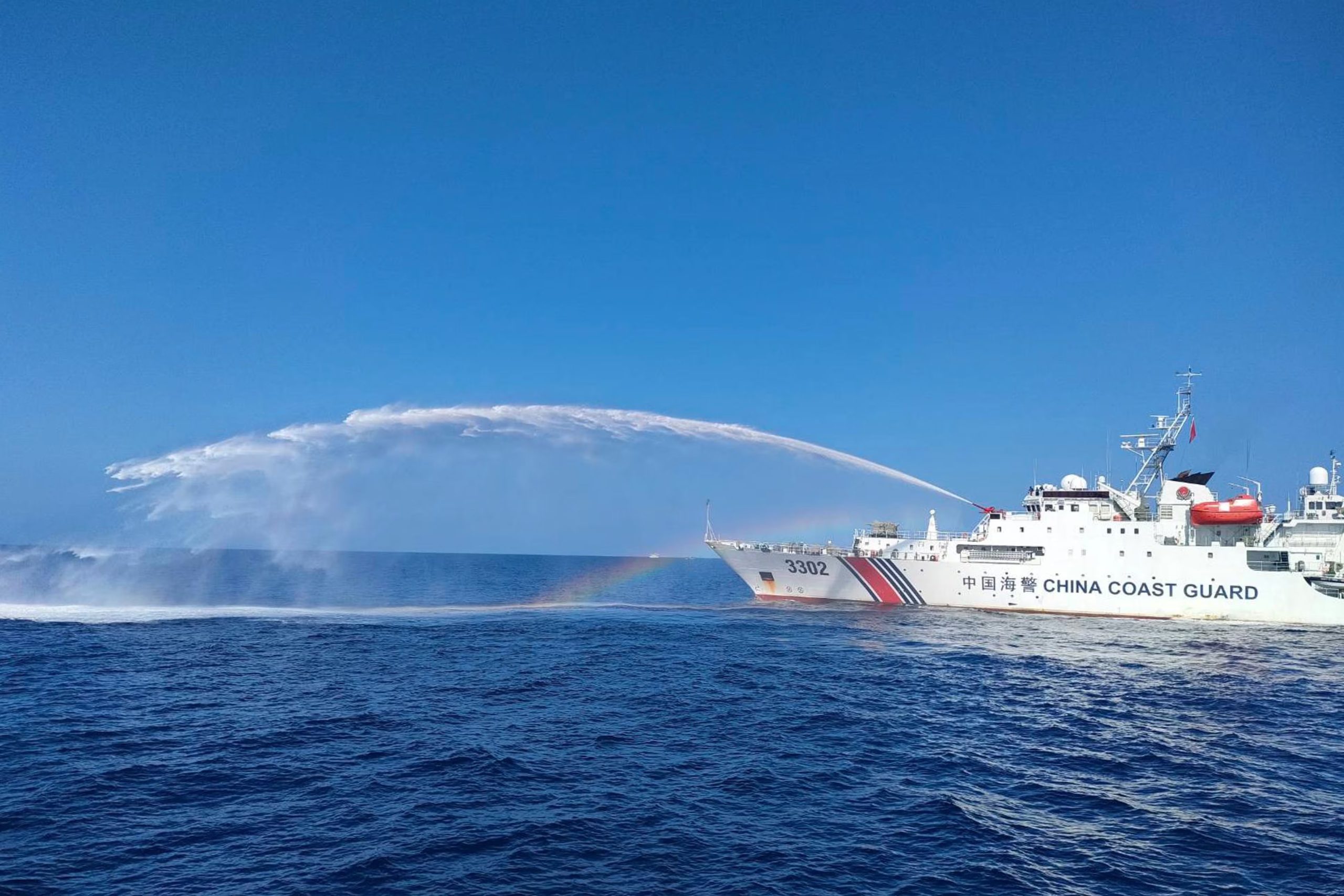 Un barco de la guardia costera china lanza agua contra un barco del Departamento de Pesca y Recursos Acuáticos de Filipinas, en el disputado Mar de China Meridional, el 9 de diciembre de 2023 (Guardia Costera de Filipinas vía AP)