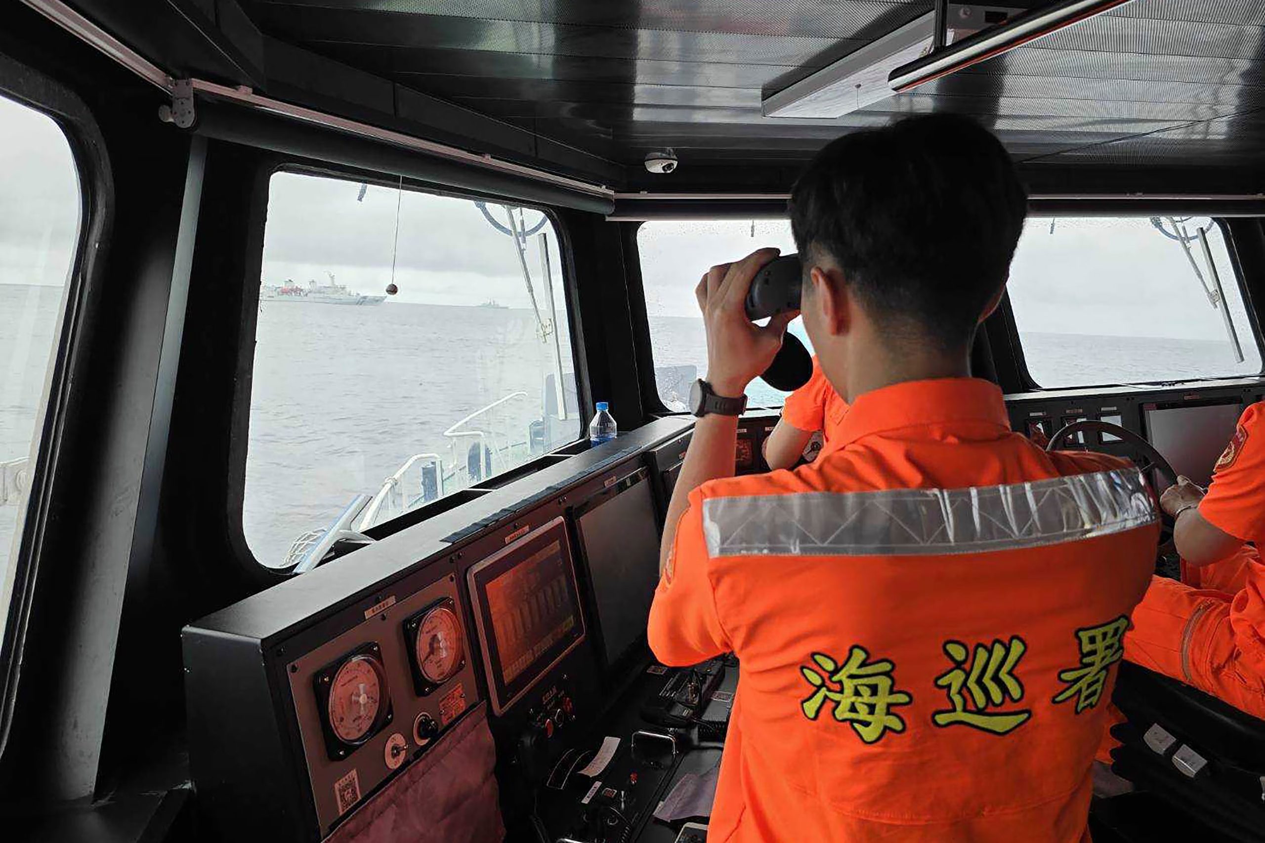 En esta imagen, distribuida por la Guardia Costera de Taiwán, un efectivo vigila un buque de la marina de China (Guardia Costera de Taiwán vía AP/Archivo)