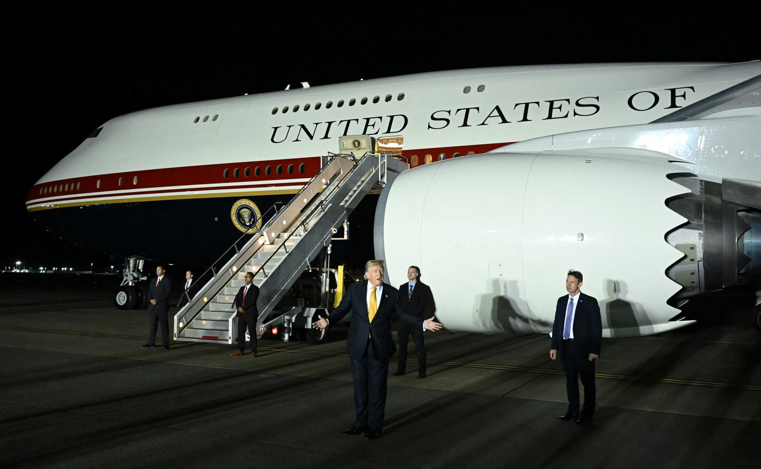 Donald Trump saluda frente al Air Force One luego de hacer el pase de aviones en la base de la Royal Air Force británica en Mildenhall. Desde allí se embarcó en el nuevo avión a los Estados Unidos y habló con los periodistas a bordo (Photo by SAUL LOEB / AFP)