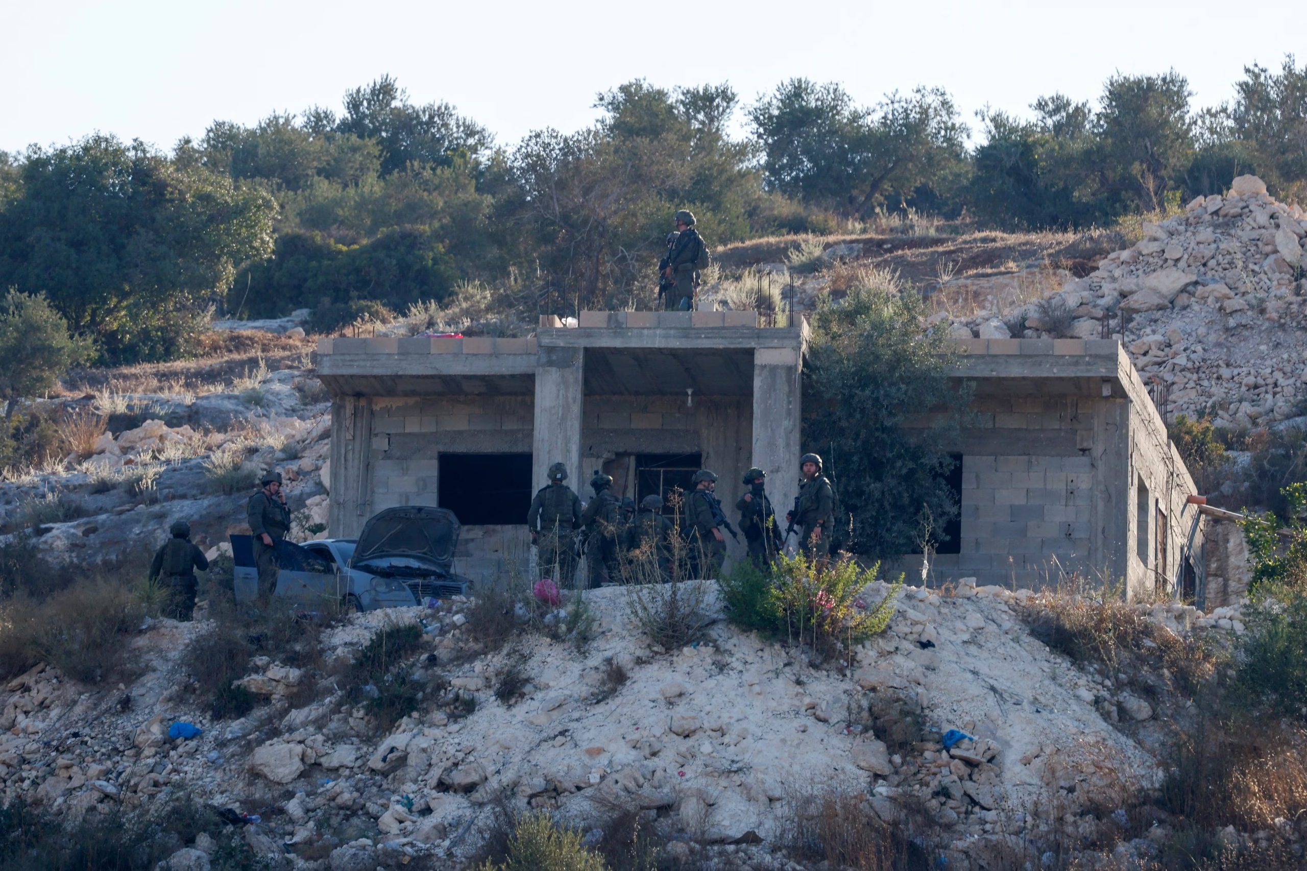 Fuerzas militares israelíes permanecen junto a un edificio, tras un ataque aéreo militar israelí, en Jenin, en la Cisjordania ocupada por Israel, el 28 de agosto de 2026. REUTERS/Mohammed Torokman