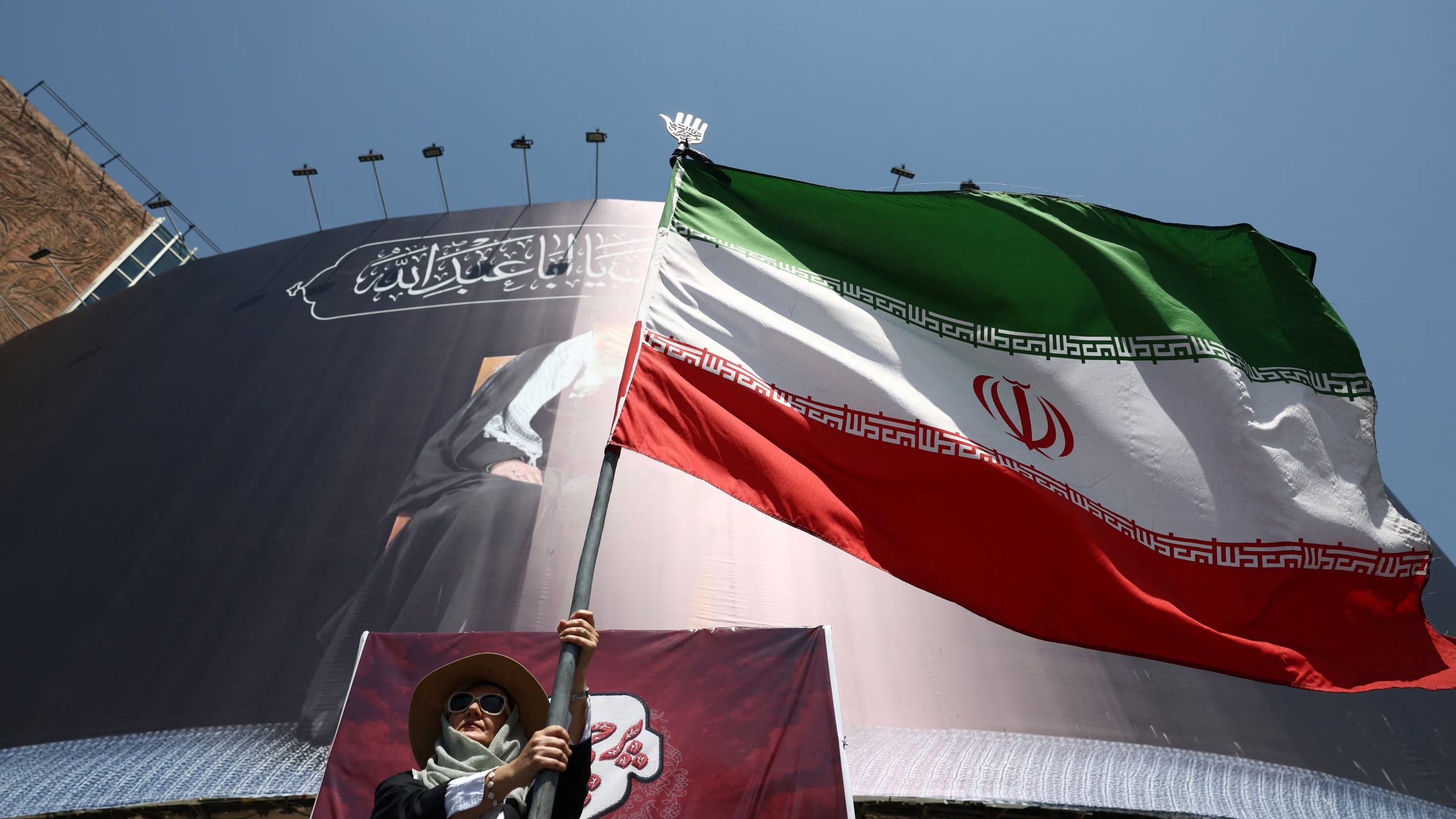 Una mujer sostiene una bandera iraní en una calle de Teherán, Irán, el 30 de junio de 2026 (Majid Asgaripour/WANA vía REUTERS)