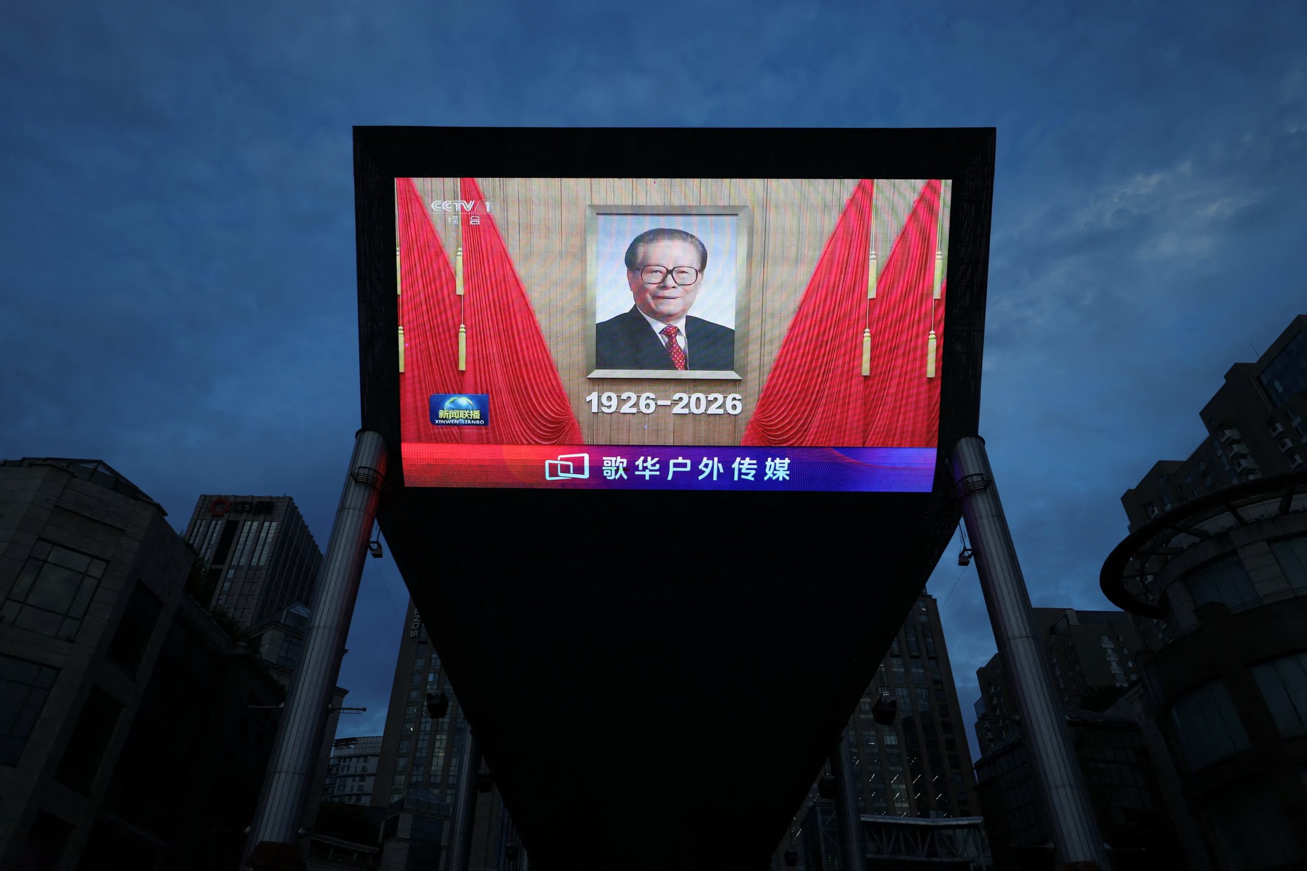 Una pantalla gigante muestra una grabación de noticias con un retrato del fallecido líder Jiang Zemin durante un evento conmemorativo por el centenario de su nacimiento, en Pekín, China (REUTERS/Tingshu Wang)