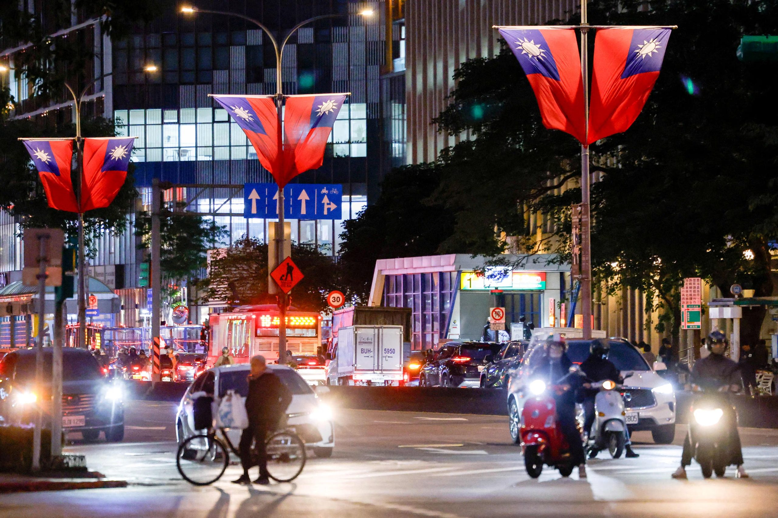 ARCHIVO: Automóviles y motocicletas esperan en un semáforo en una calle decorada con banderas de Taiwán en Taipéi, Taiwán, el 30 de diciembre de 2025 (Reuters)