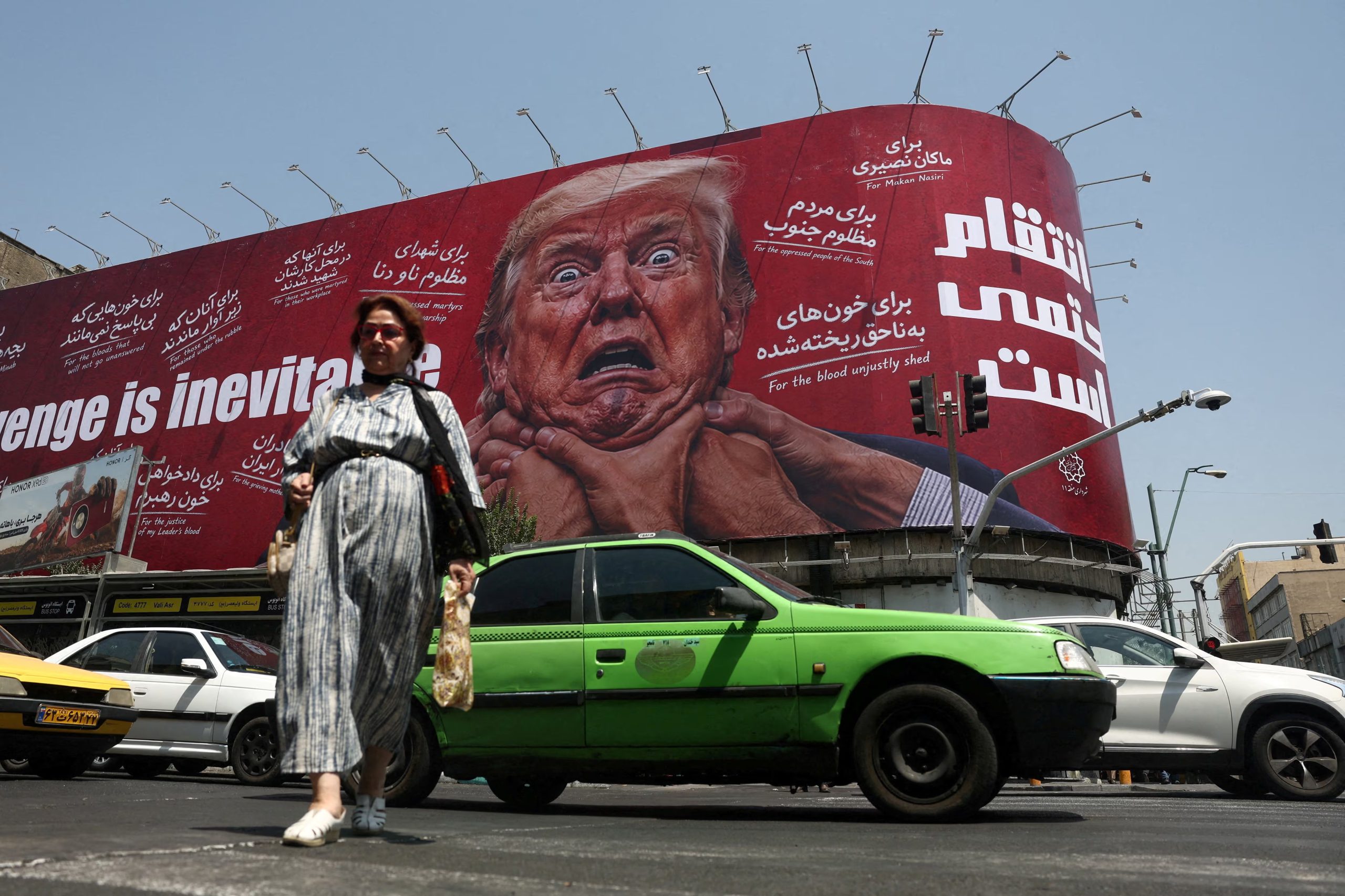 Una mujer camina cerca de una valla publicitaria con la imagen del presidente estadounidense, Donald Trump, en un edificio de Teherán, Irán, el 27 de julio de 2026 (REUTERS)